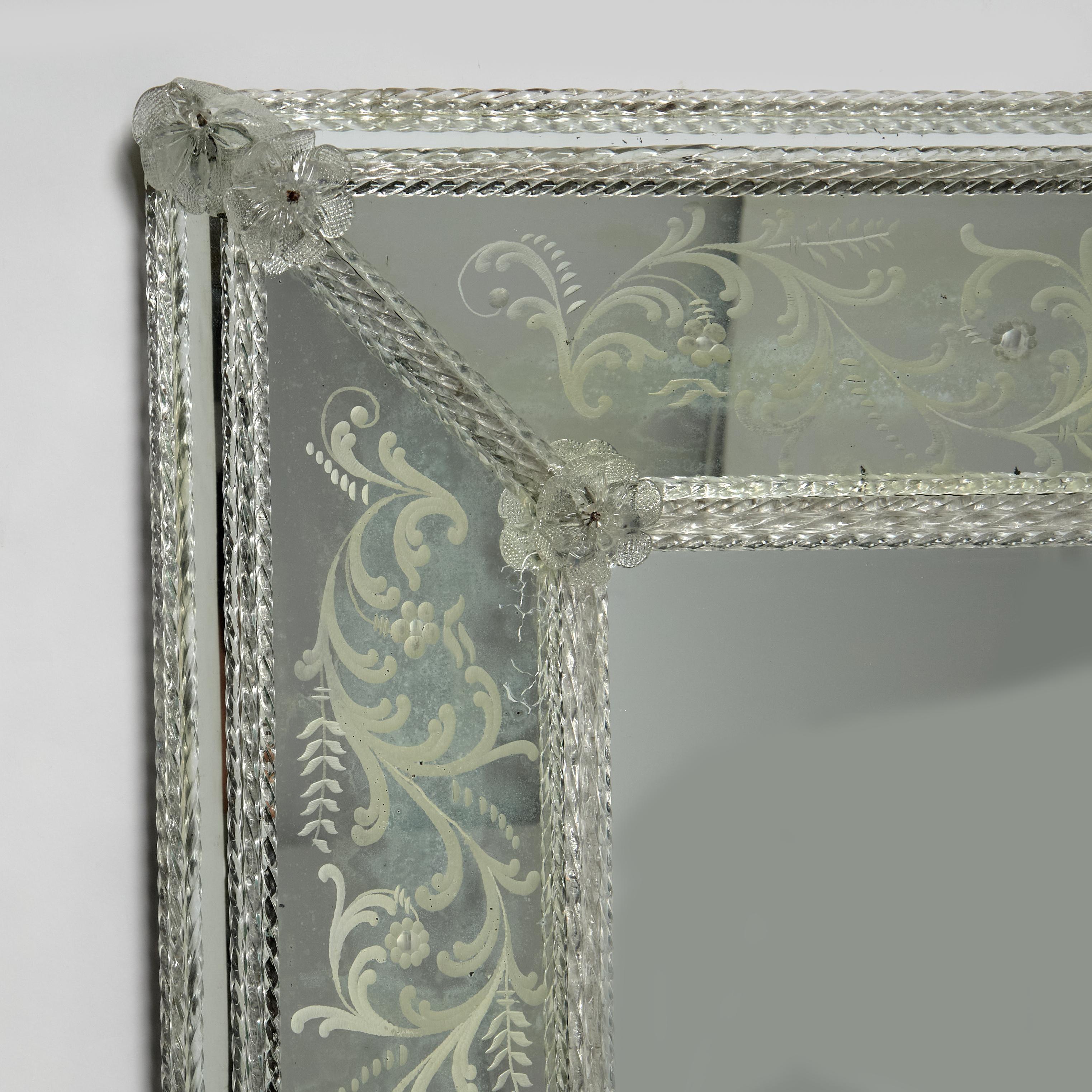 Impressionnant miroir mural italien ancien présentant des panneaux gravés à l'envers avec des motifs floraux classiques à l'intérieur de tiges de verre torsadé soufflées à la main sur le bord extérieur et à l'intérieur avec des fleurons en verre. 