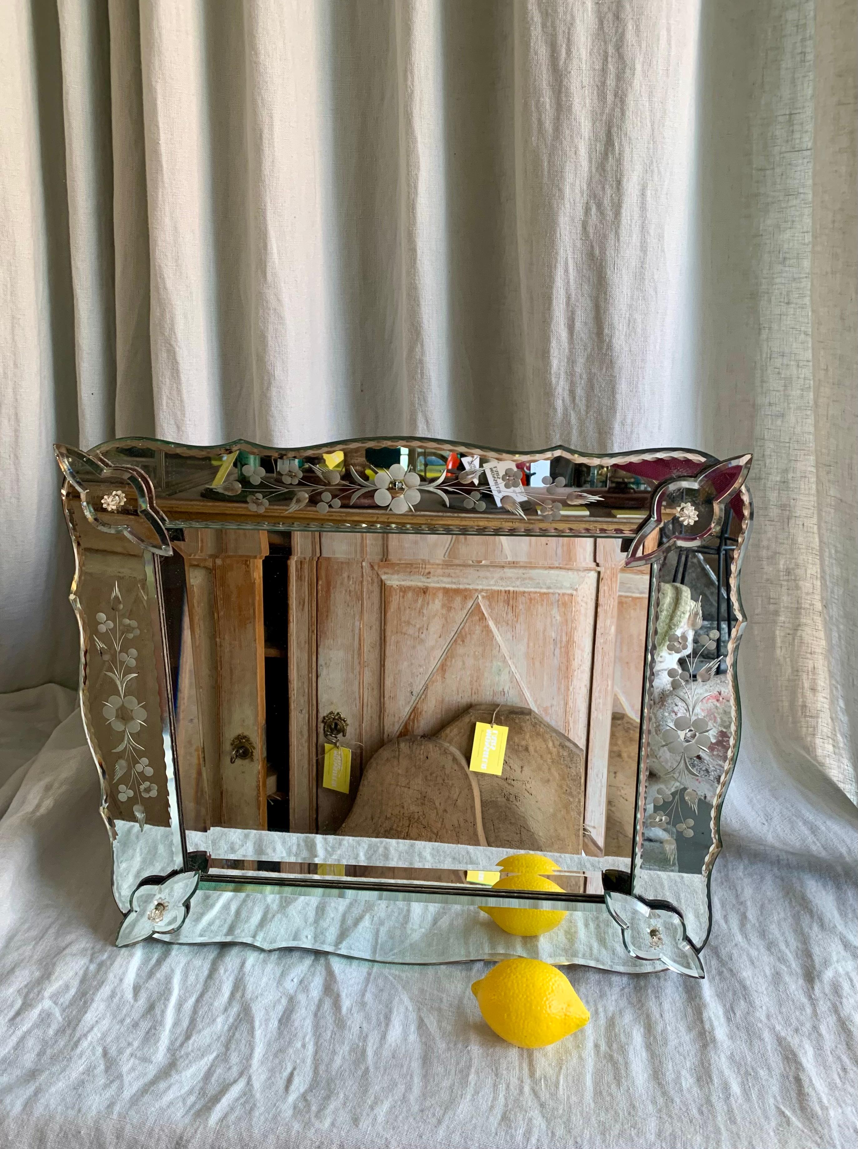 Antique French wall mirror - Venetian Style. The mirror has cut glass panels and corner ornaments with engraved decor.

