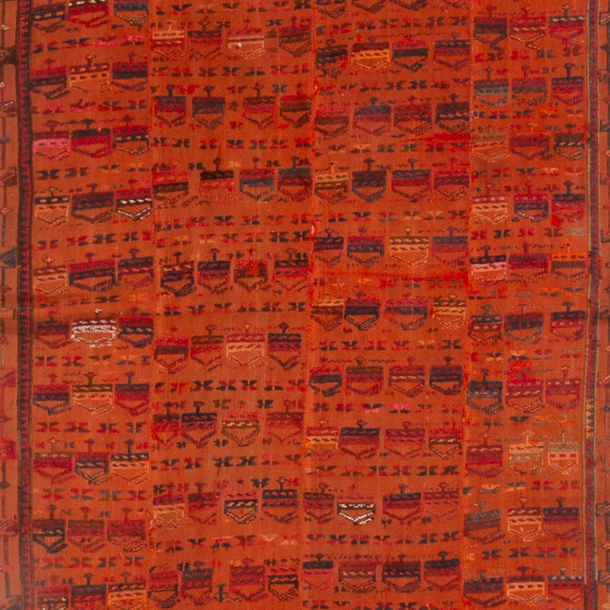 Originating from Russia in 1910, this antique traditional Verneh wool kilim is one of a select few pieces employing a distinct repetition of key marital symbolism. Flat woven in high quality wool, the deep-yet-vibrant orange field design plays host