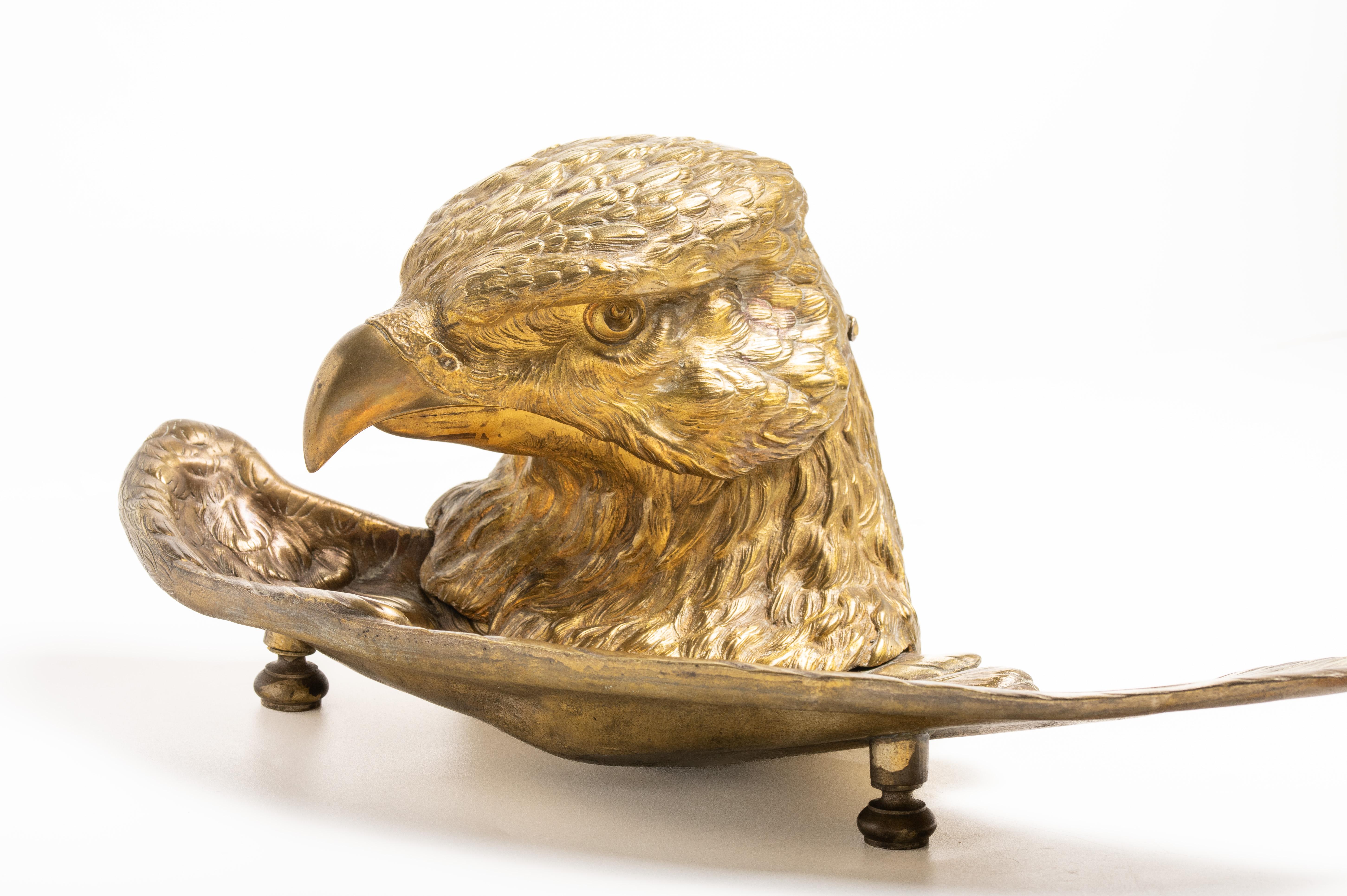 Antikes französisches vergoldetes Metall-Neuheitstintenfass in Form des Adlers. Dieses Tintenfass stammt aus dem frühen 20. Jahrhundert und wurde in Form eines Adlerkopfes und einer Vogelfeder gestaltet. Ein Adlerkopf lässt sich gut öffnen und ein