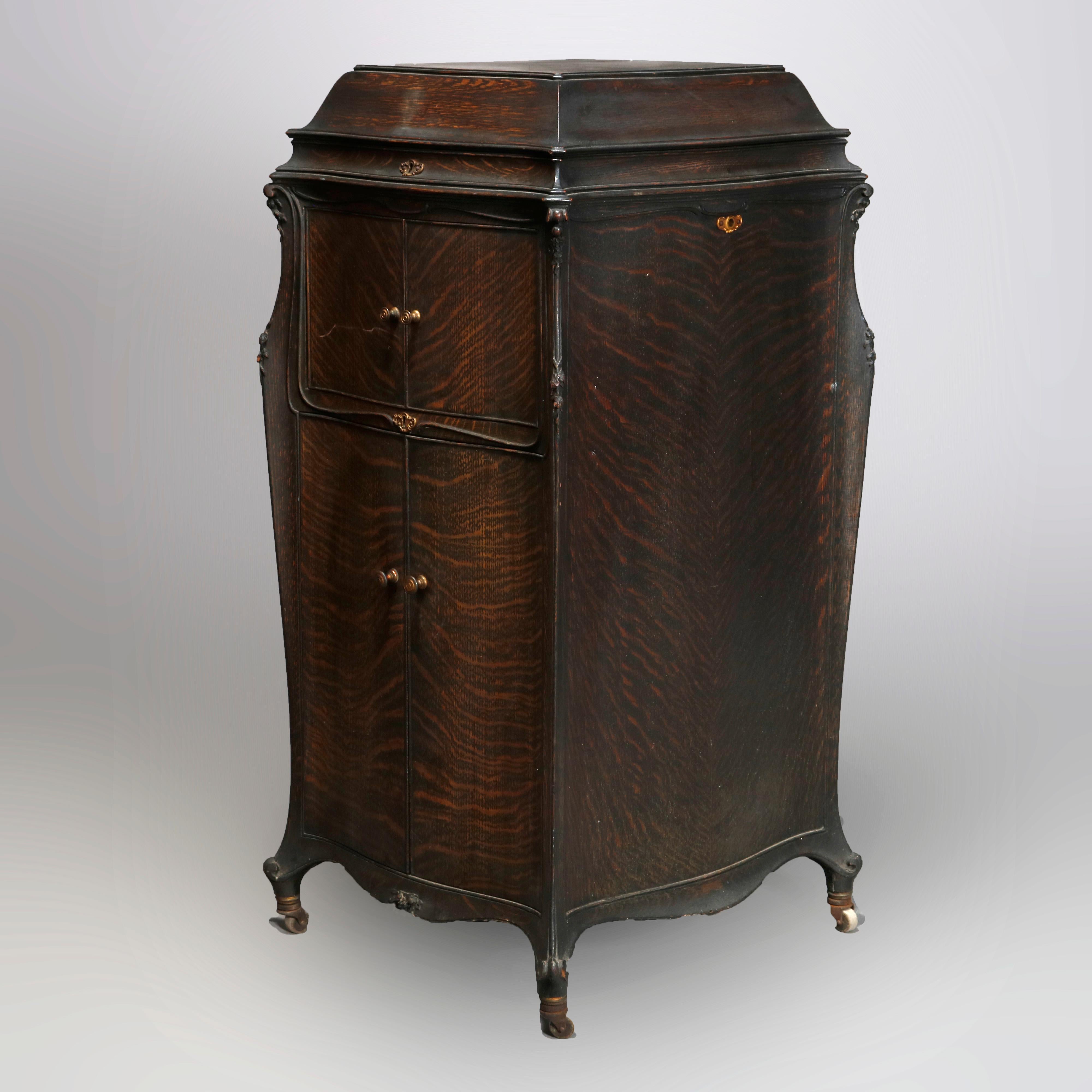 An antique French Louis XVI style Victor Victrola phonograph music box case by Clark Music Co., Syracuse, New York offers quarter sawn oak construction in serpentine form raised on scroll form feet with casters, original labels as photographed,