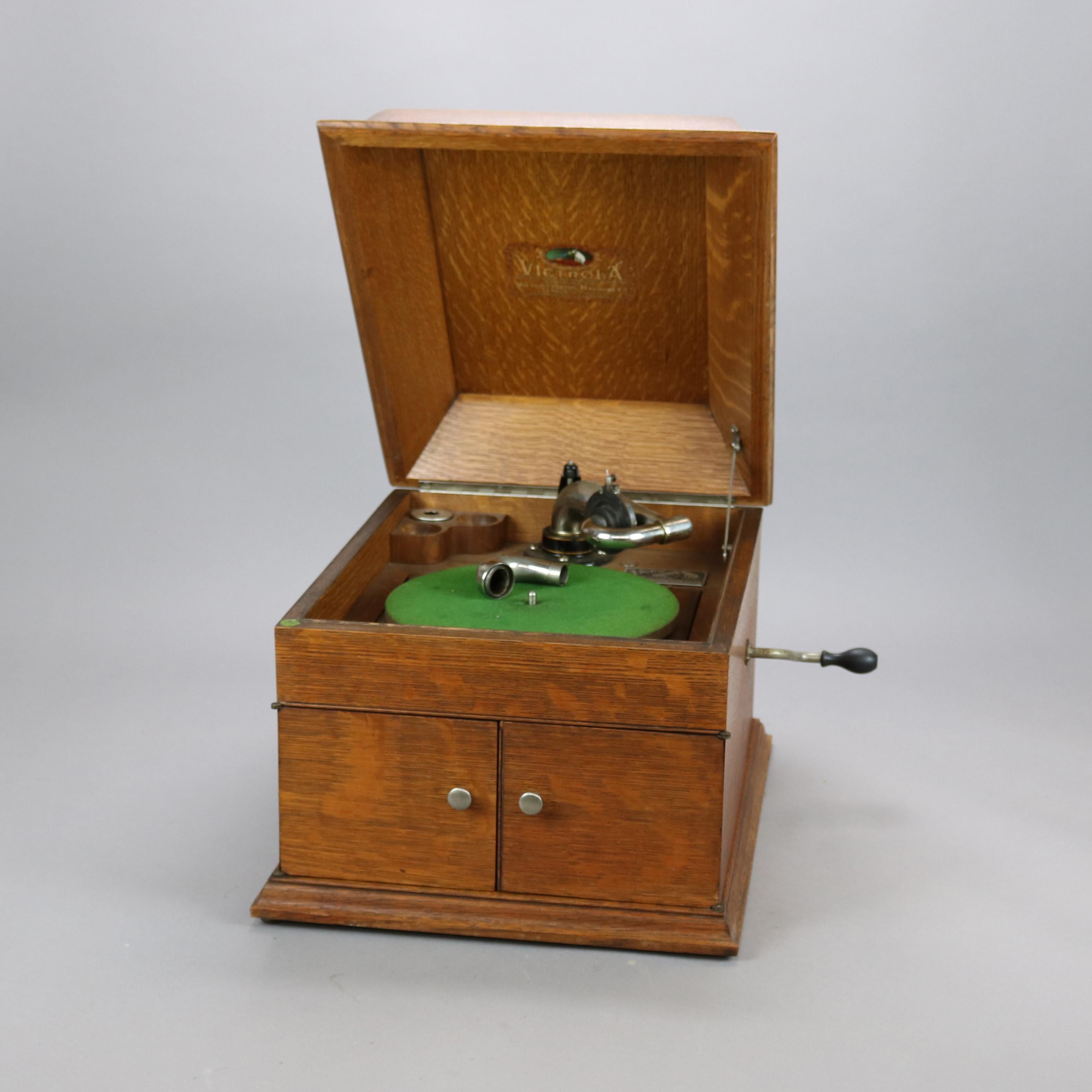 An antique Victor Victrola table top phonograph offers quarter sawn oak case with domed top and front cabinet doors opening to speaker, crank included, maker label as photographed, c1910

Measures - 12.5'' H x 18.75'' W x 19.25'' D.