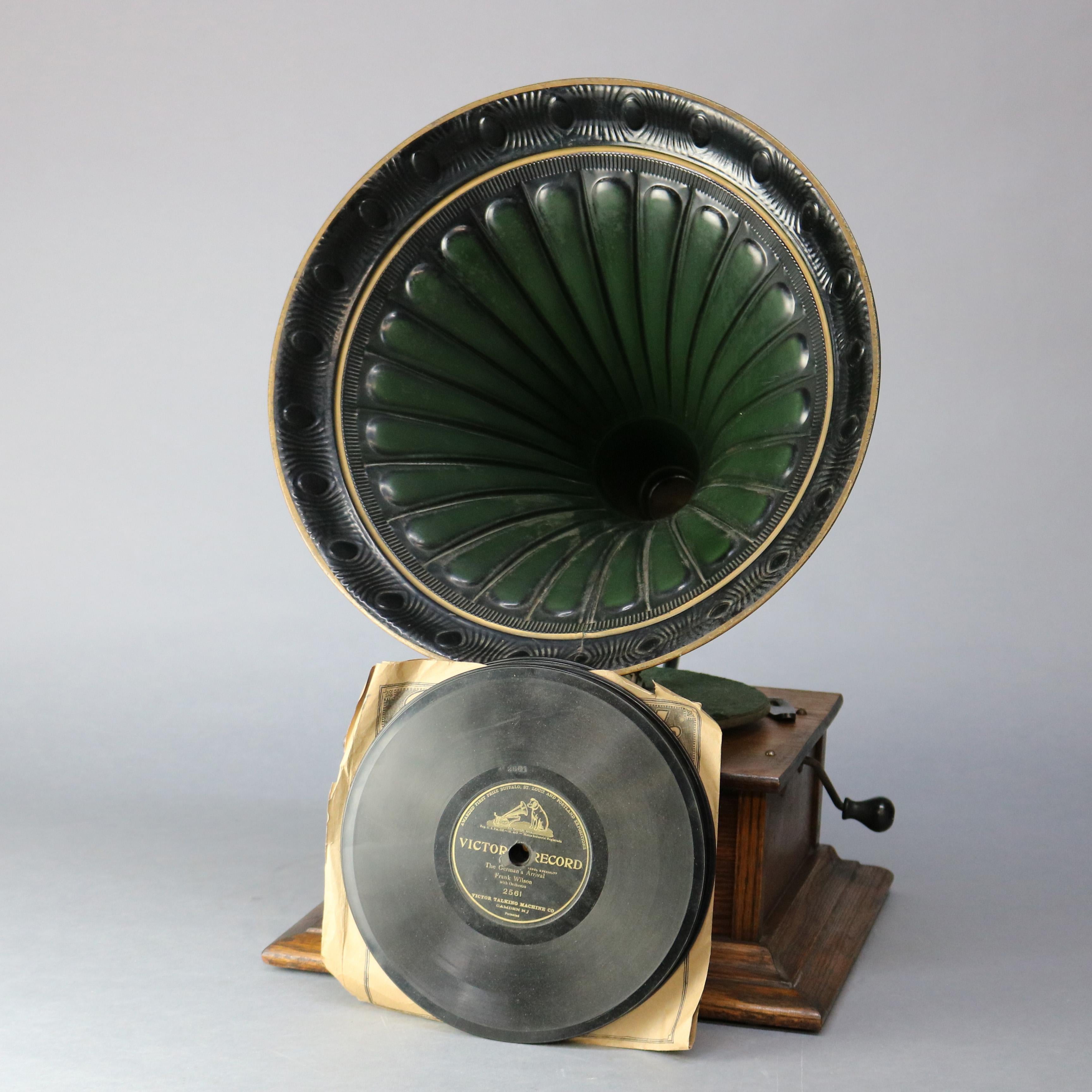 An antique Victor Victrola Standard Phonograph talking machine offers oak case with crank outside fluted horn and records, original label as photographed, complete works and unknown working condition, circa 1900.

Measures: 25.5