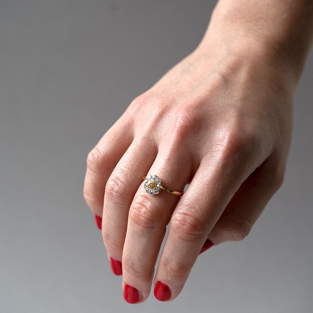 Bague marguerite en diamant jaune de fantaisie 0,35ct d'époque victorienne sertie en or jaune 18ct. Cette somptueuse bague ancienne présente un riche diamant jaune central entouré d'un halo de diamants blancs vifs de 0,65 ct.  

MESURES
Diamètre de