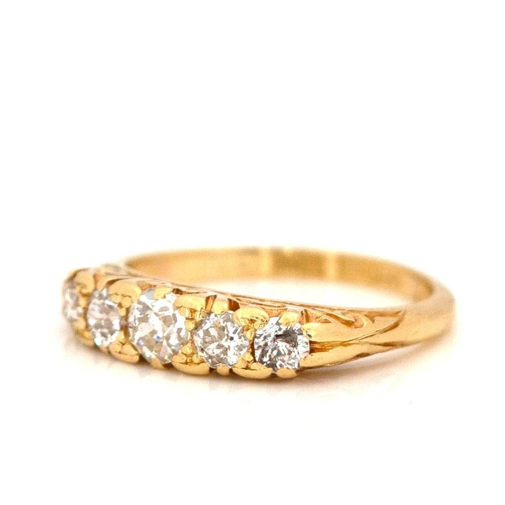 Explore the elegance of the Victorian era with our Antique 0.6ct five stone diamond 18ct gold ring. This piece features five diamonds totaling 0.60 carats, set in an 18ct gold band with an ornate design typical of the period. The craftsmanship