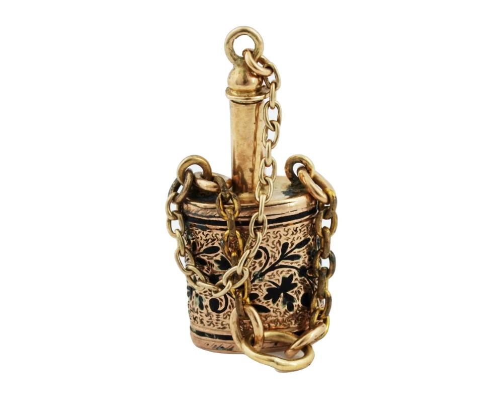 Un ancien flacon de parfum victorien en or 10 K.K., vers le milieu du 19e siècle. La pièce est modelée comme un vaisseau miniature orné de motifs floraux gravés et recouverts d'émail noir. Une chaîne séparée est prévue pour utiliser la pièce comme