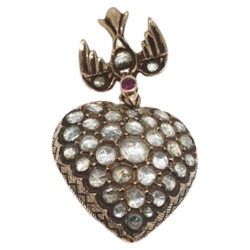 Antique voctorian era heart pendant with rose cut diamonds estimate weight 3.5 carats back foiled with a hanging swallow bird decorted with a ruby stone and detaled engraved work on the back 