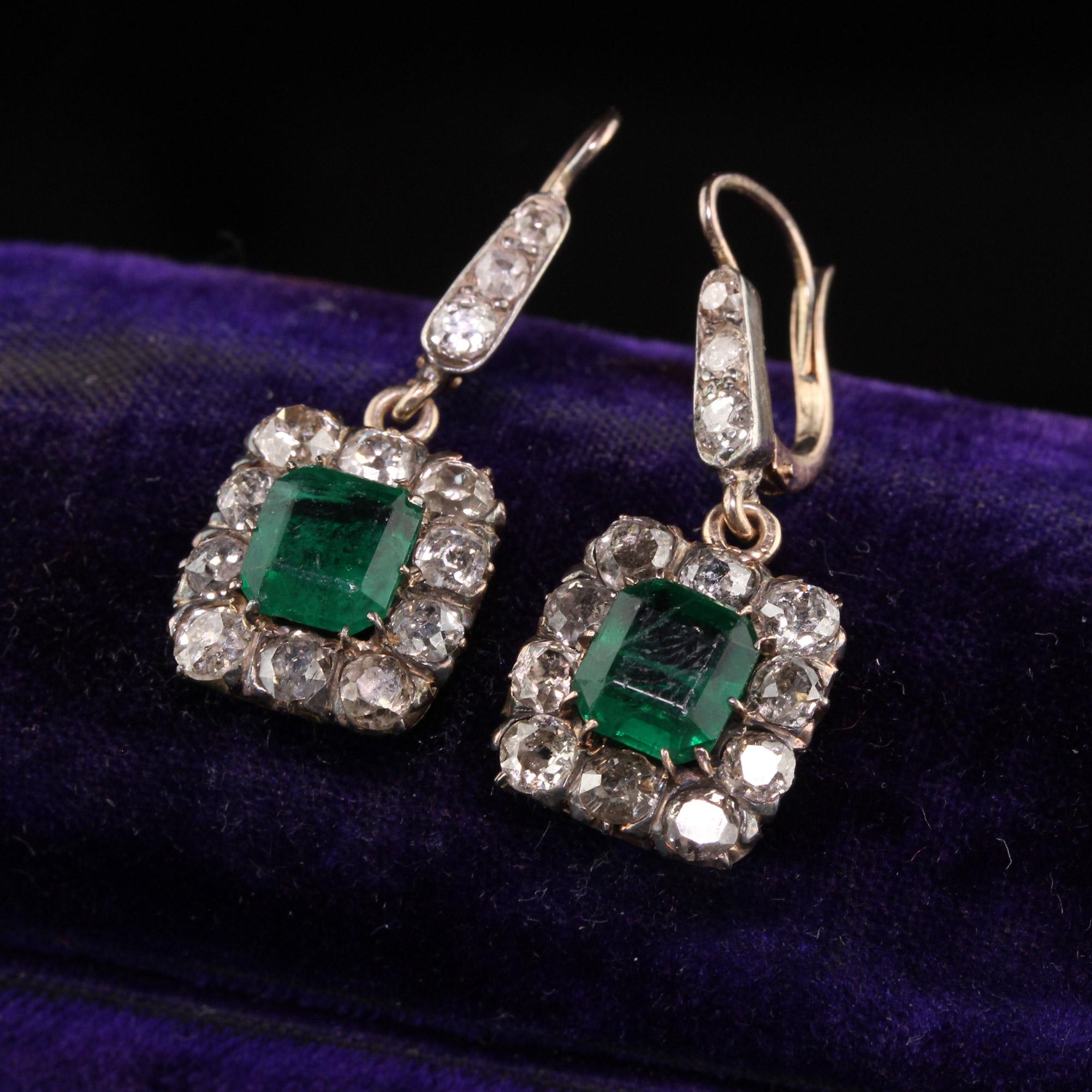 Beautiful Antique Victorian 10K Yellow Gold Old Mine Cut Diamond Drop Earrings. This beautiful pair of earrings is crafted in 10k yellow gold and silver top. The diamonds are all chunky old mine cut and the center emeralds are synthetic but have