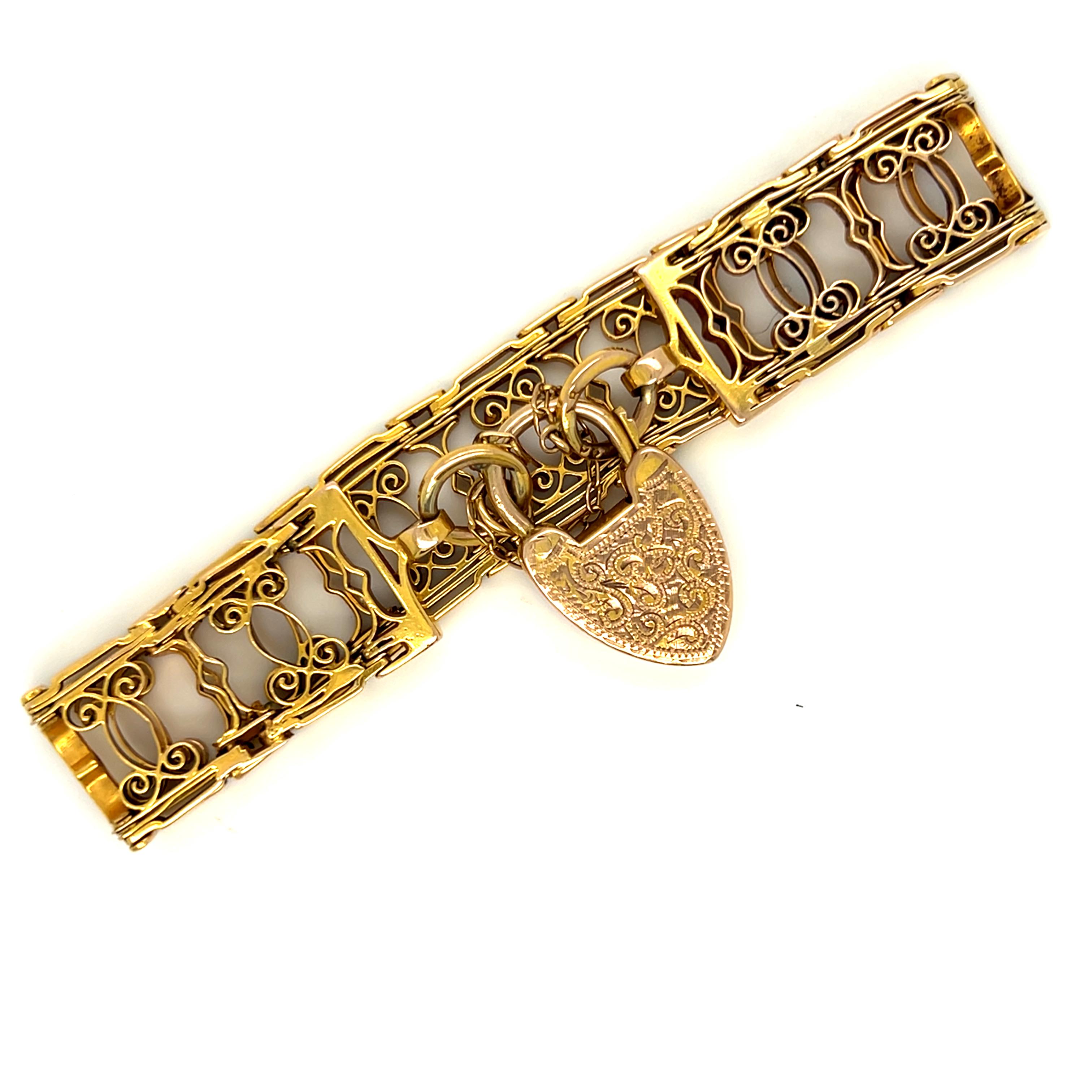 Adoro questo antico bracciale vittoriano in oro giallo 12K con lucchetto a cuore! Super unico, diventerà sicuramente un cimelio di famiglia. Realizzato in oro giallo 12 carati, il design è caratterizzato da pannelli di scorrimento lavorati a mano e