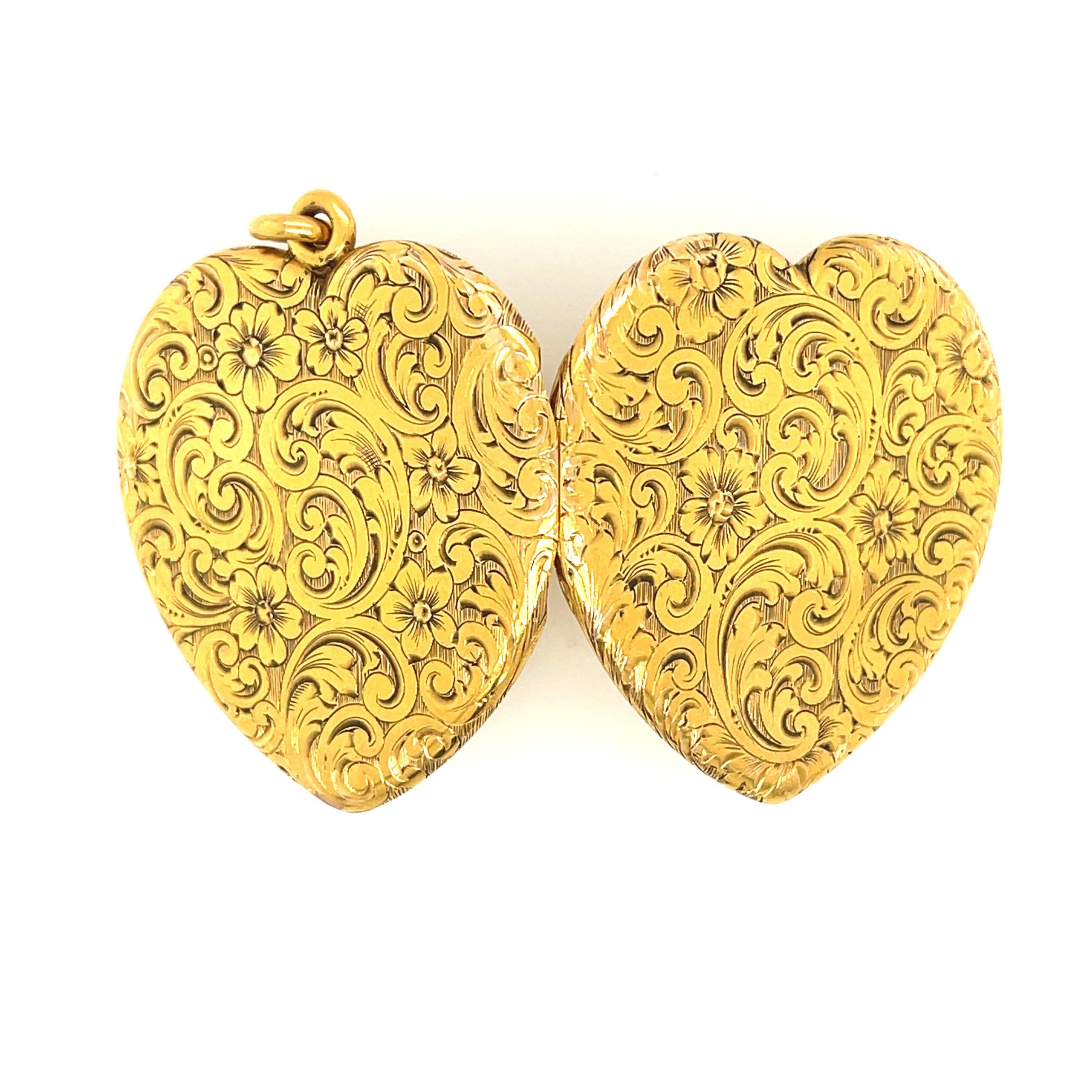 A large 14k yellow gold engraved heart locket circa 1890. This beautifully rendered heart has scroll engraving all over the front and the back of the locket. The locket opens and can hold photos. The heart is marked 14k on the inside of the locket.
