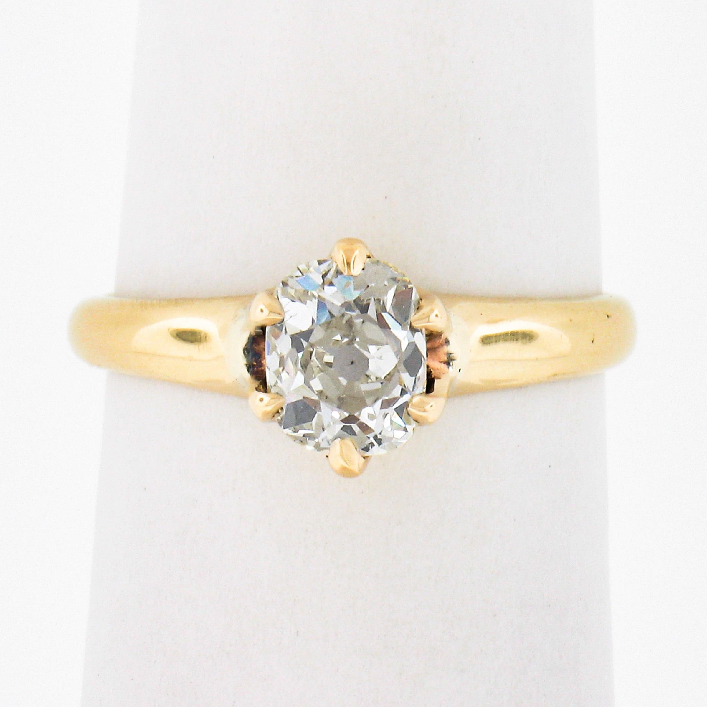This beautiful, petite, antique diamond solitaire ring was crafted from solid 14k yellow gold during the Victorian era. The ring features an old mine cushion cut diamond solitaire which is claw prong set at the center. This diamond has a lot of