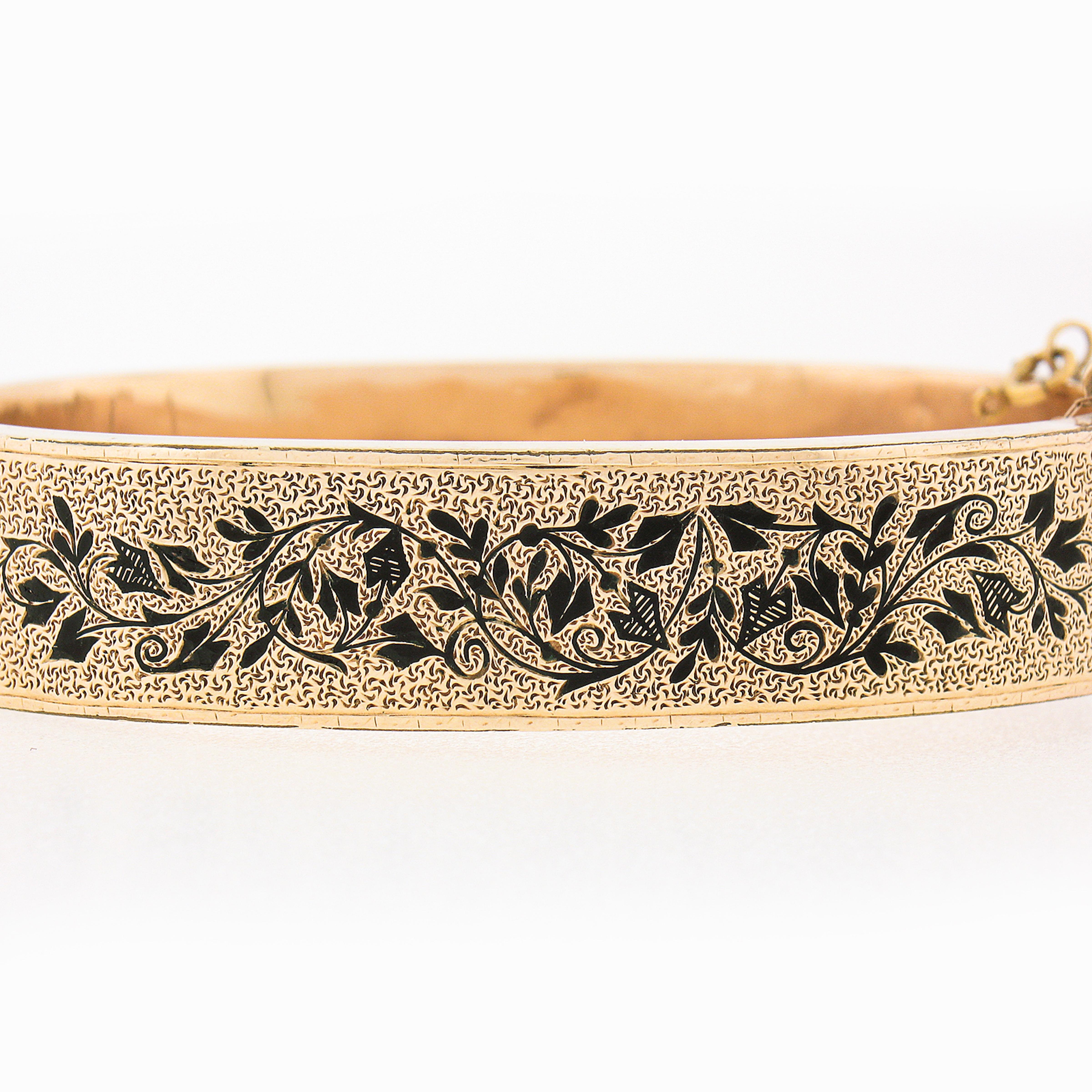 This unique and absolutely gorgeous antique bangle bracelet was crafted in solid 14k gold during the Victorian period and features a wide design covered with incredible textured work throughout, and adorned with two sides of very fine and neat black
