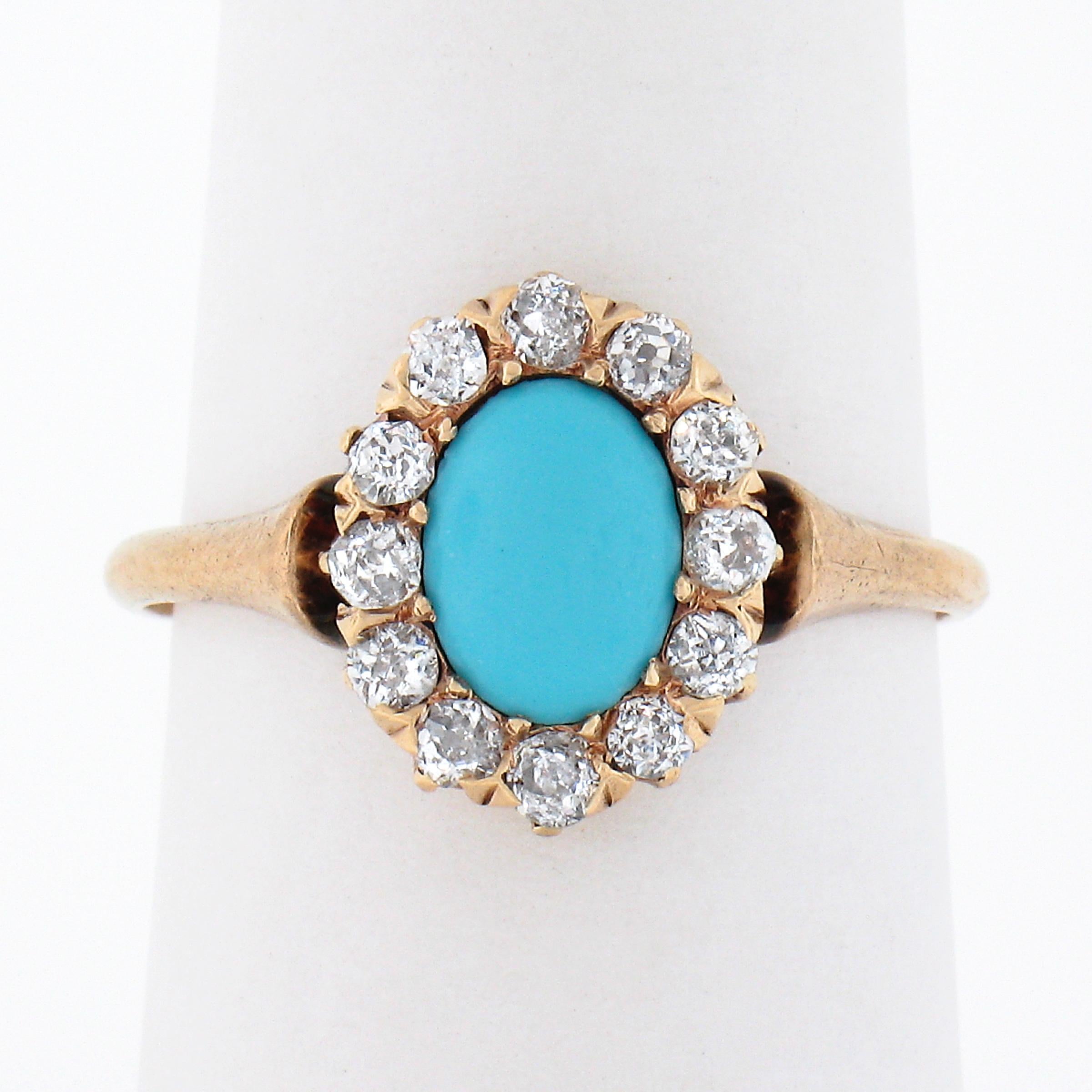 This lovely antique ring was crafted during the Victorian era in solid 14k gold and features a beautiful natural turquoise stone neatly set at the center of a lively old mine cut diamond halo. The fine oval cabochon cut turquoise shows a gorgeous
