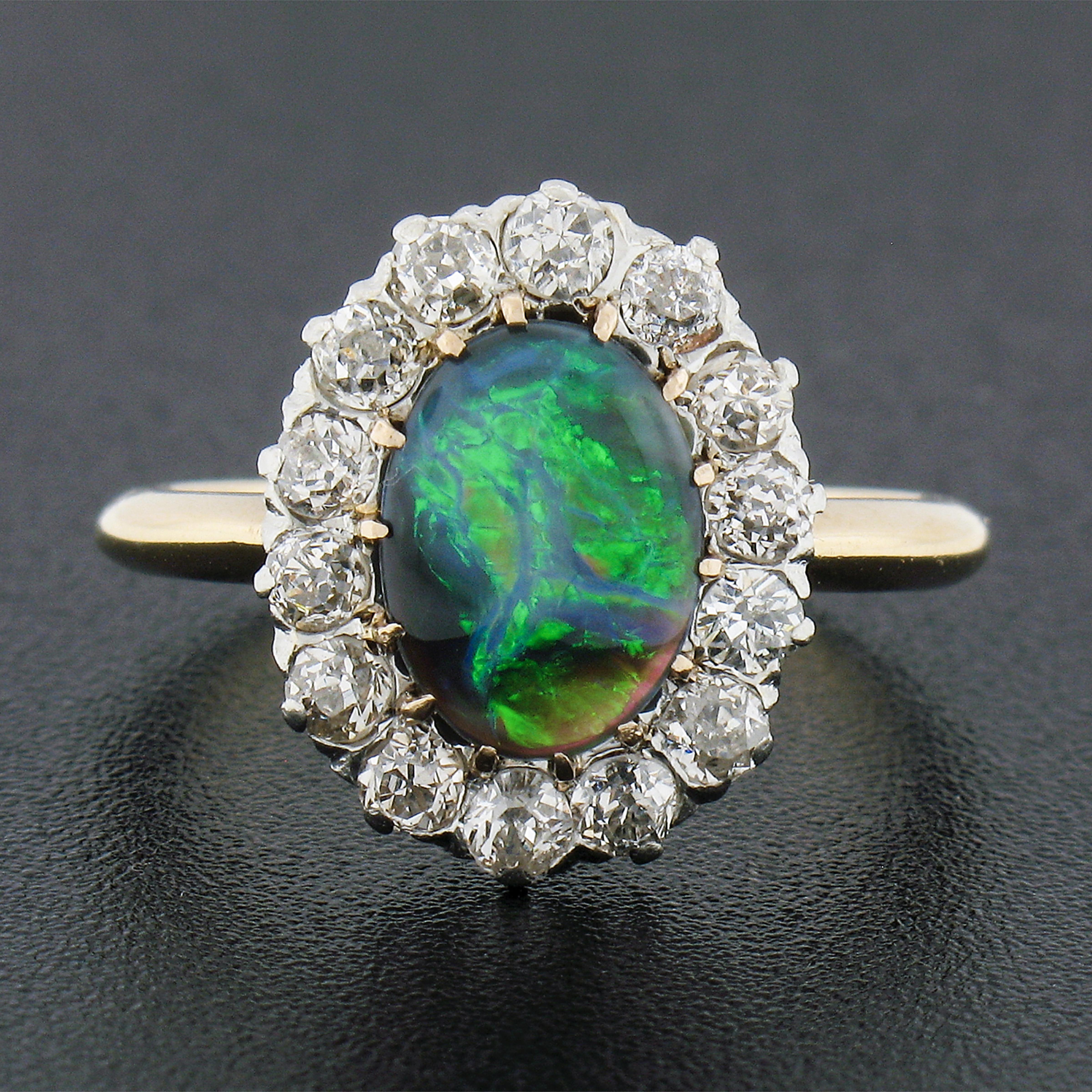 This magnificent antique ring is crafted in solid 14k gold with a platinum top and features a breathtaking gray opal gemstone neatly and elegantly multi-prong set at the center of stunning halo design. The gray opal is in excellent condition, has no