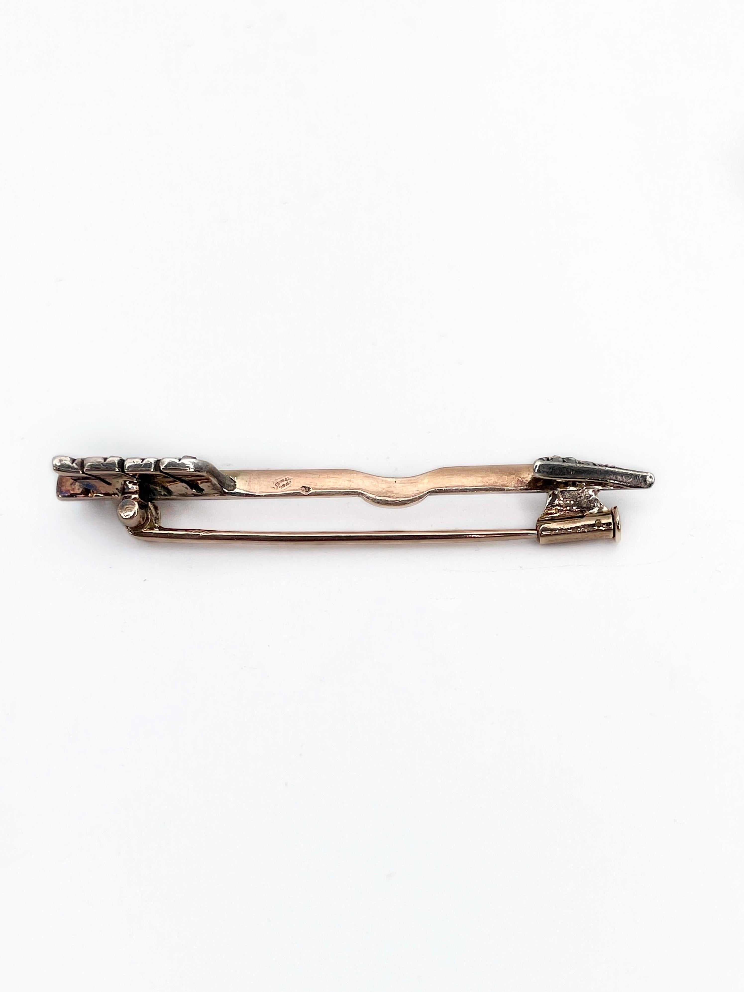 This is a lovely Victorian arrow bar brooch crafted in 14K rose gold in early XX century. The piece is adorned with silver. It features 24 rose cut diamonds. 

The bar has a decorative curve in the middle which gives the brooch more dynamic. You can