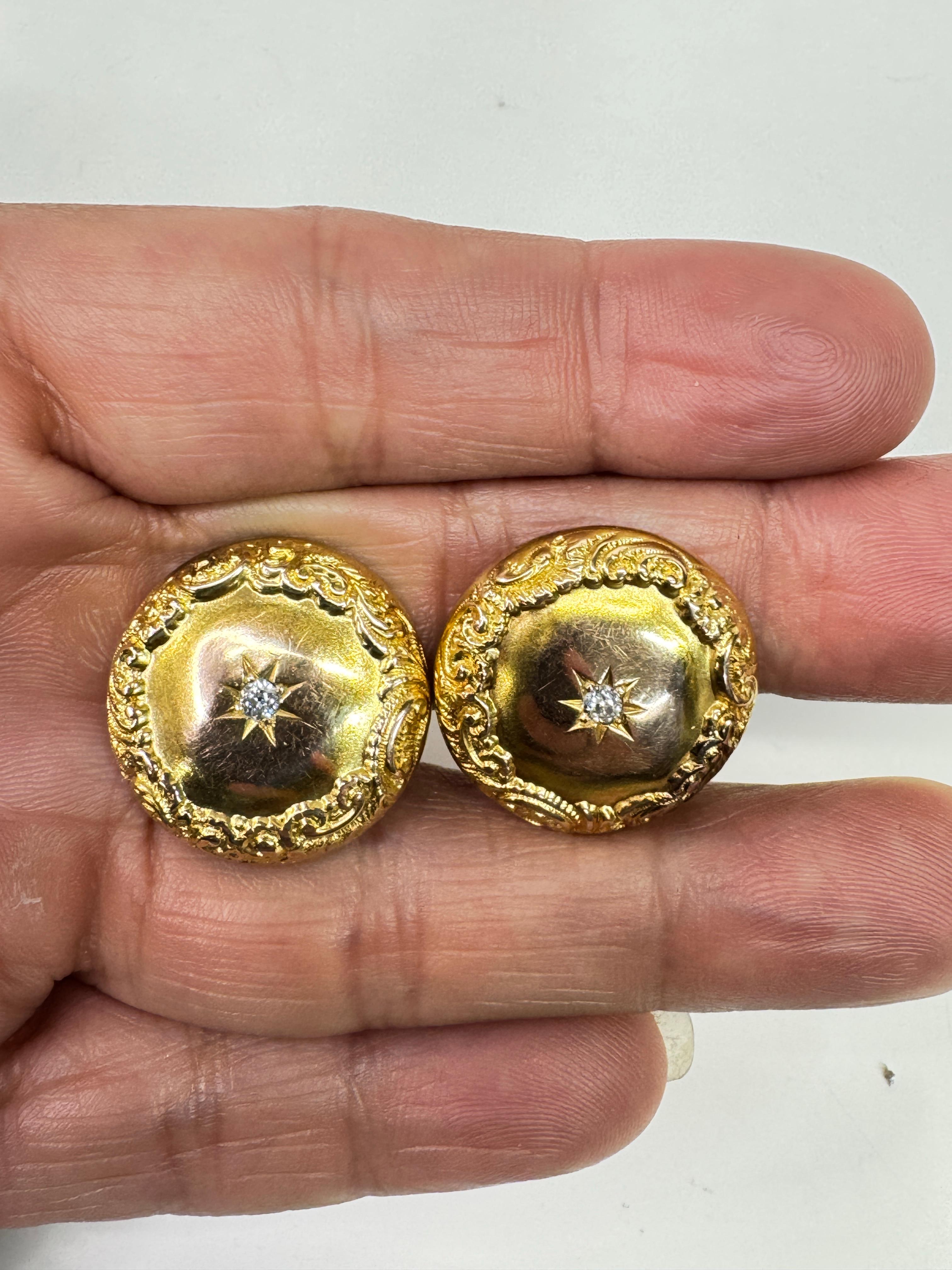 Boutons de manchette victoriens en or 10K, centre en diamant étoilé 0,10 carat. Une paire de boutons de manchette victoriens en or jaune 10 carats présentant un rond avec des façades à motif de volutes, des centres de diamants sertis en étoile, et