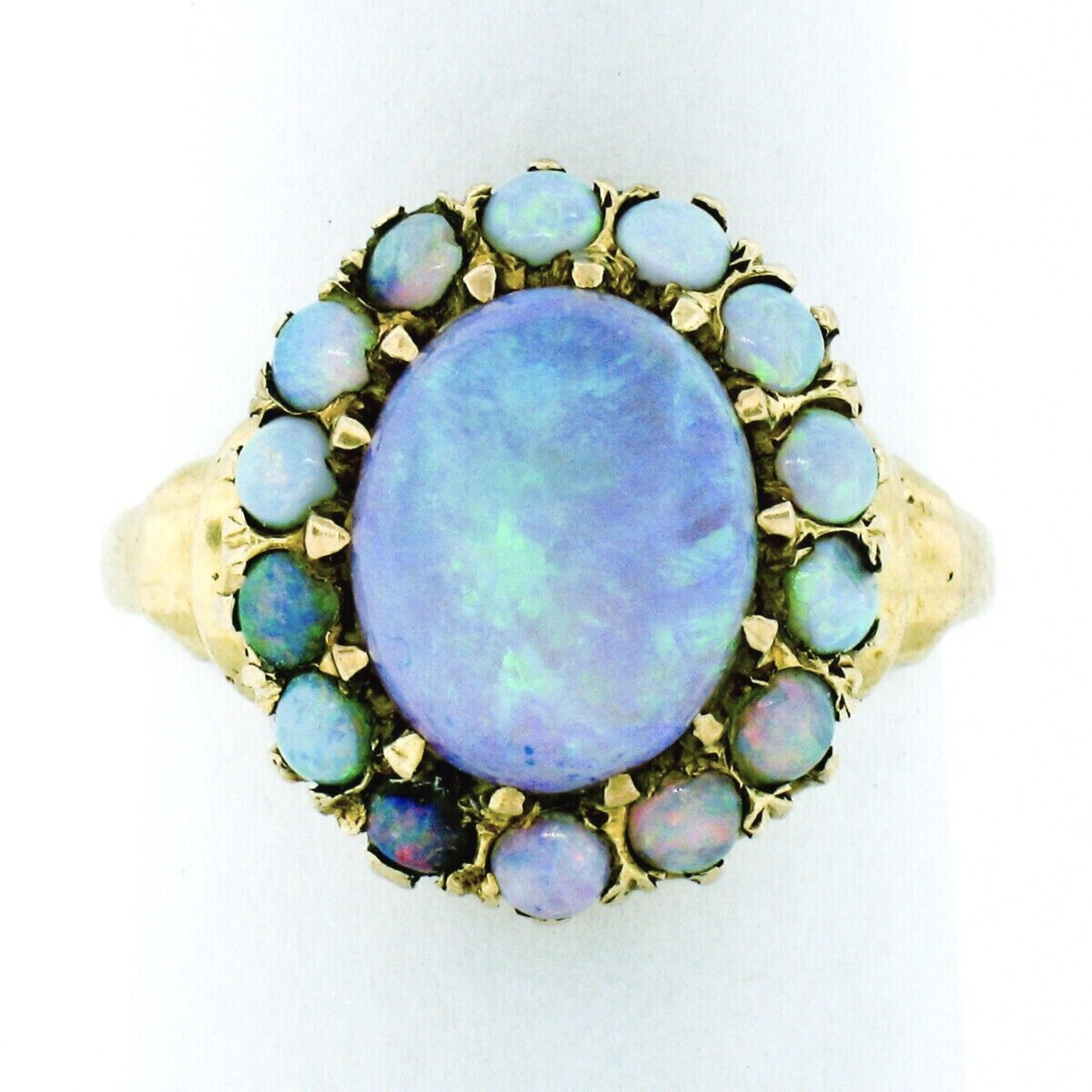 This gorgeous, hand made, antique piece was crafted in solid 14k yellow gold during the Victorian period. It features a stunning oval cabochon opal stone having a translucent white base color and displays the most amazing green and violet play