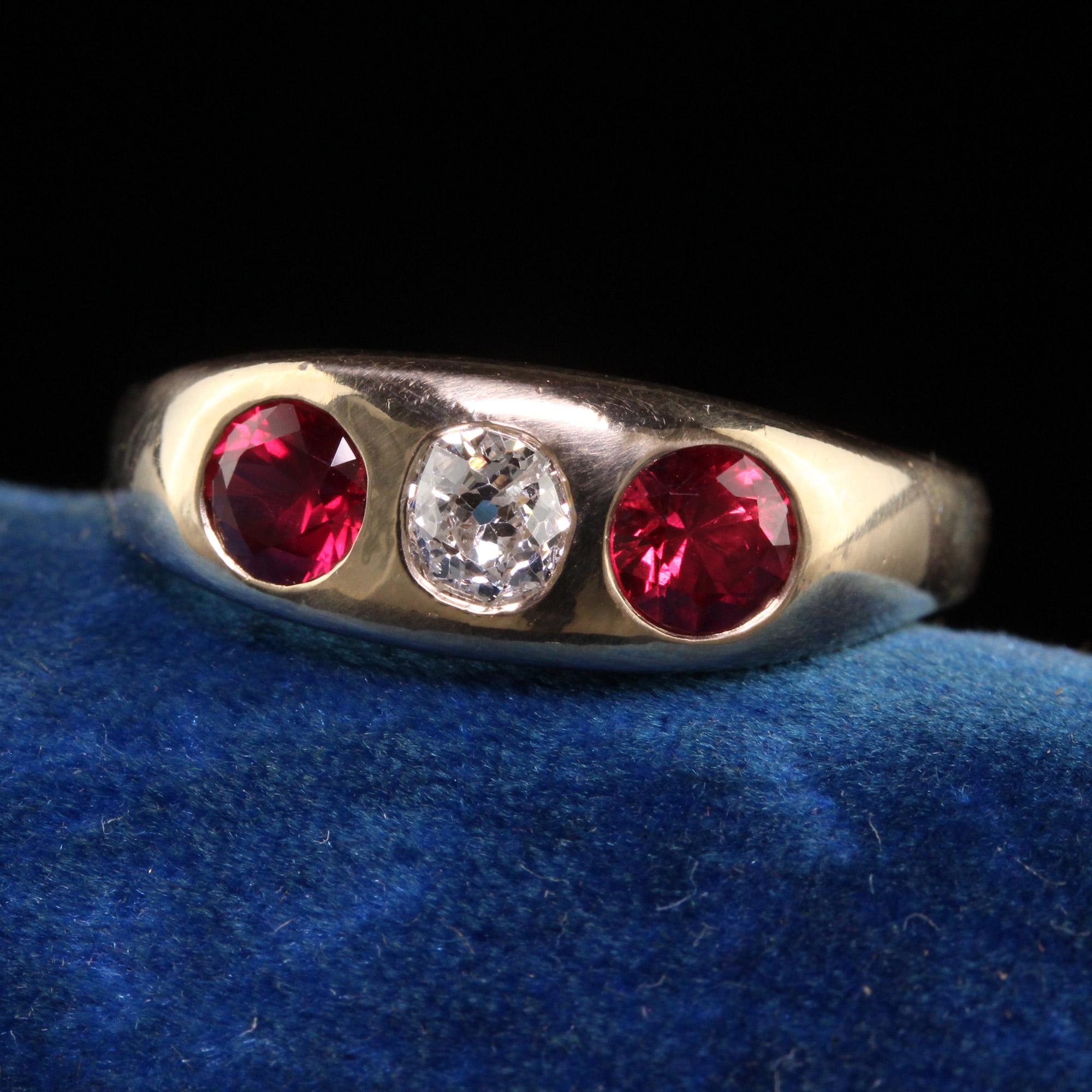 Beautiful Antique Victorian 14k Yellow Gold Natural Ruby Old Mine Diamond Flush Set Ring. This gorgeous ring is crafted in 14k yellow gold. The center holds an old mine cut diamond and has two natural vivid red rubies on each side. The ring has a