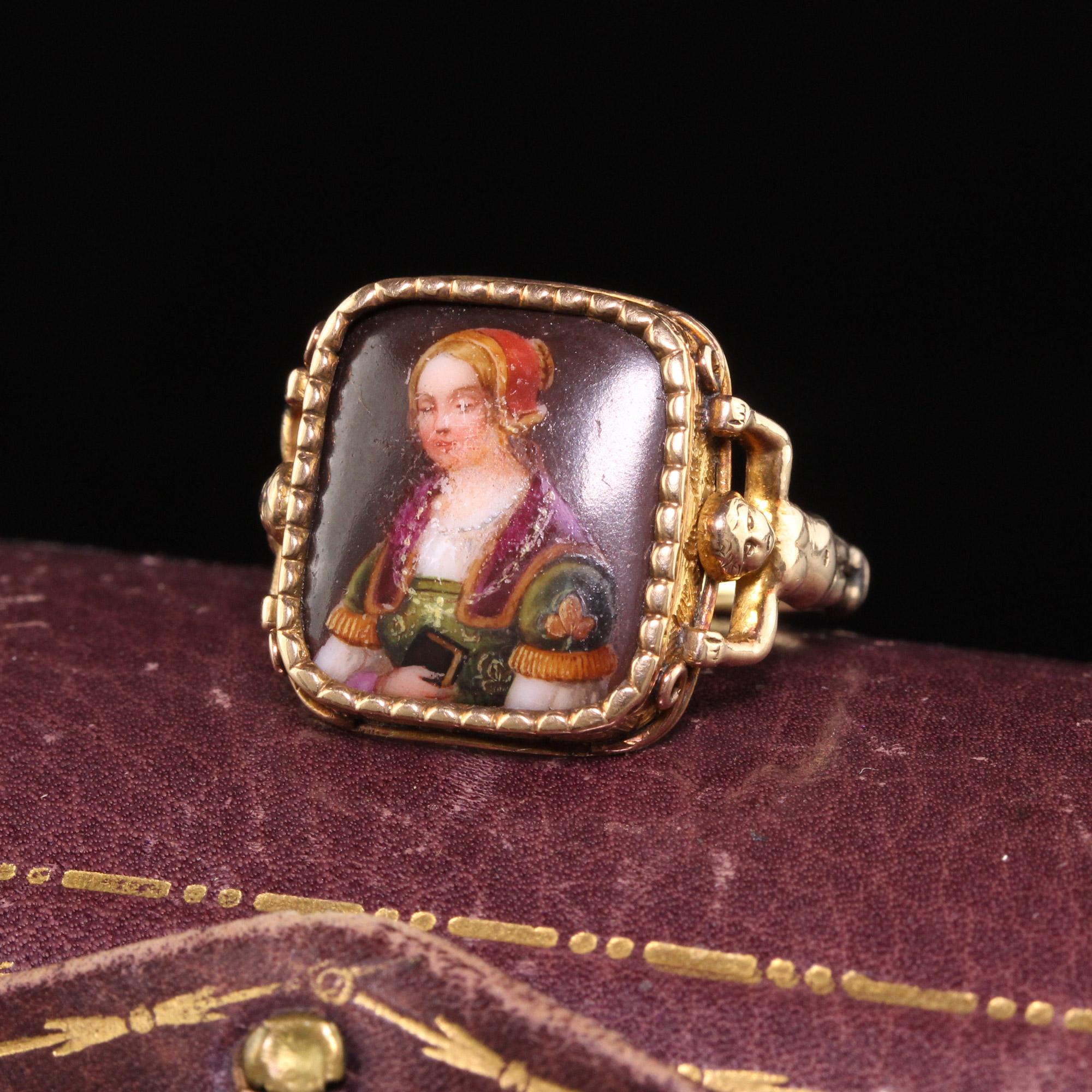 Beautiful Antique Victorian 14K Yellow Gold Unique Portrait Engraved Ring. This incredible ring is crafted in 14k yellow gold. The center holds a porcelain painting of a woman in fine clothing. The back of it is engraved M.I. MEE 1902. The sides of