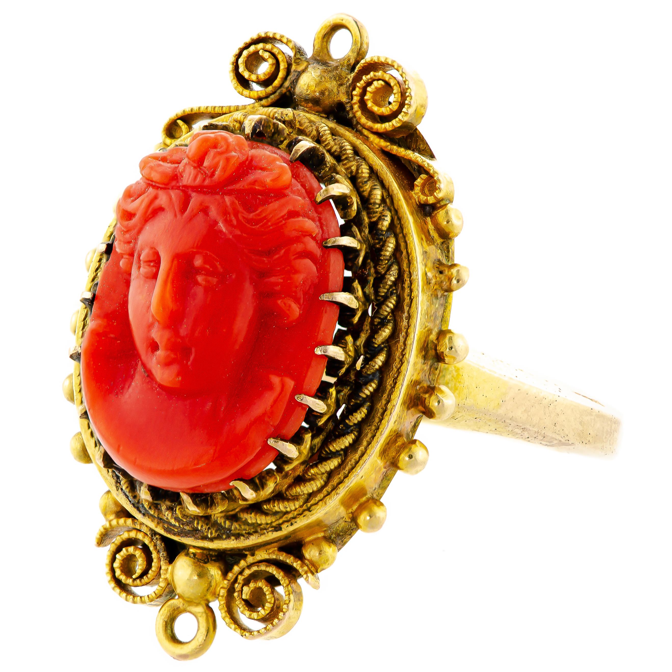 Antique Victorian 14kt yellow gold and coral cameo ring consisting of one oval coral cameo, frontal view of a Beauty in Profile measuring approximately 13.1, by 9.7mm prong set int an elaborate ring mount embellished with beading, twisted ropework