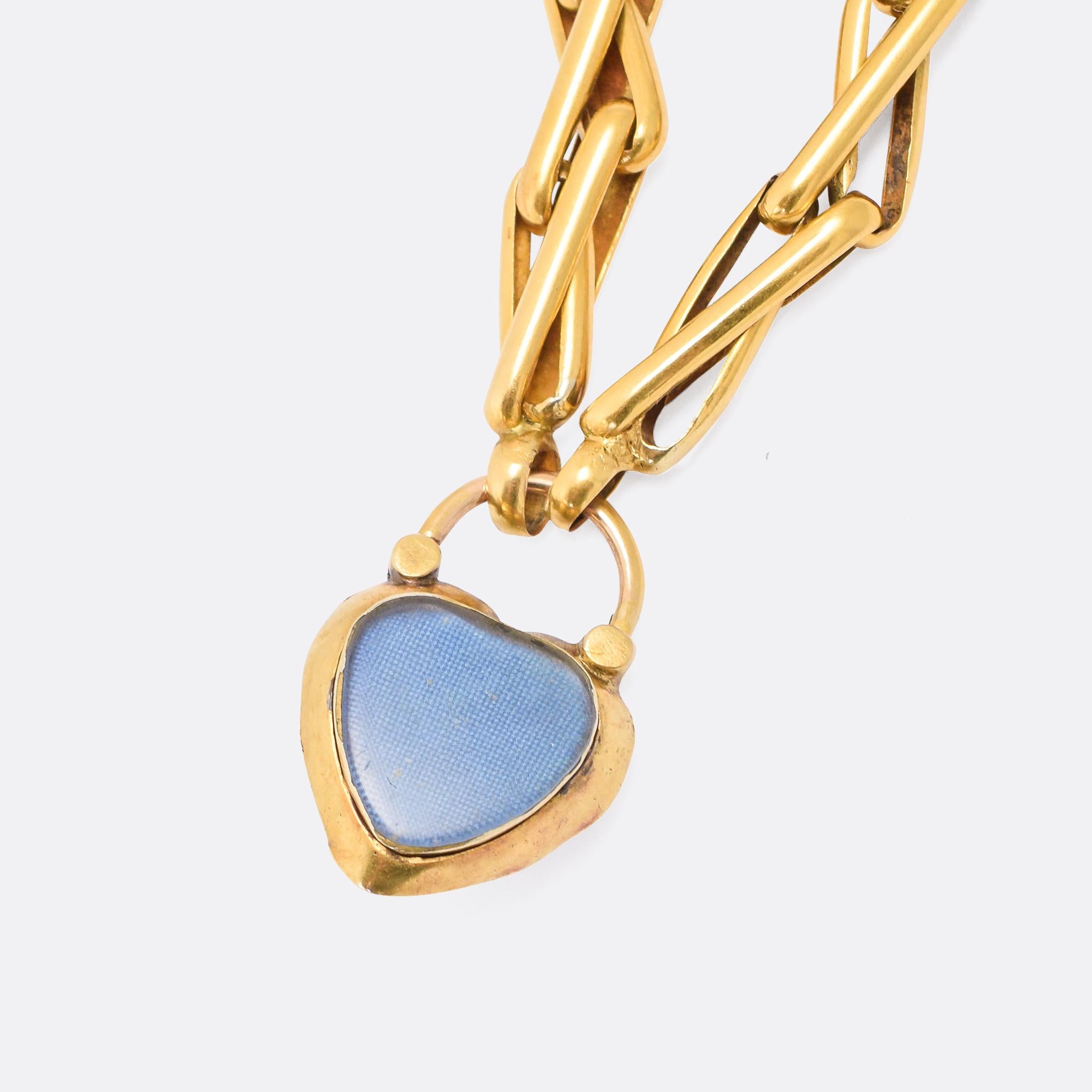 A gorgeous Victorian bracelet with twisted bar links and a garnet-set heart padlock clasp. It's modelled in 15 karat gold throughout, the clasp featuring deeply chased rococo-style ornamentation and a glass locket compartment to the reverse.

STONES