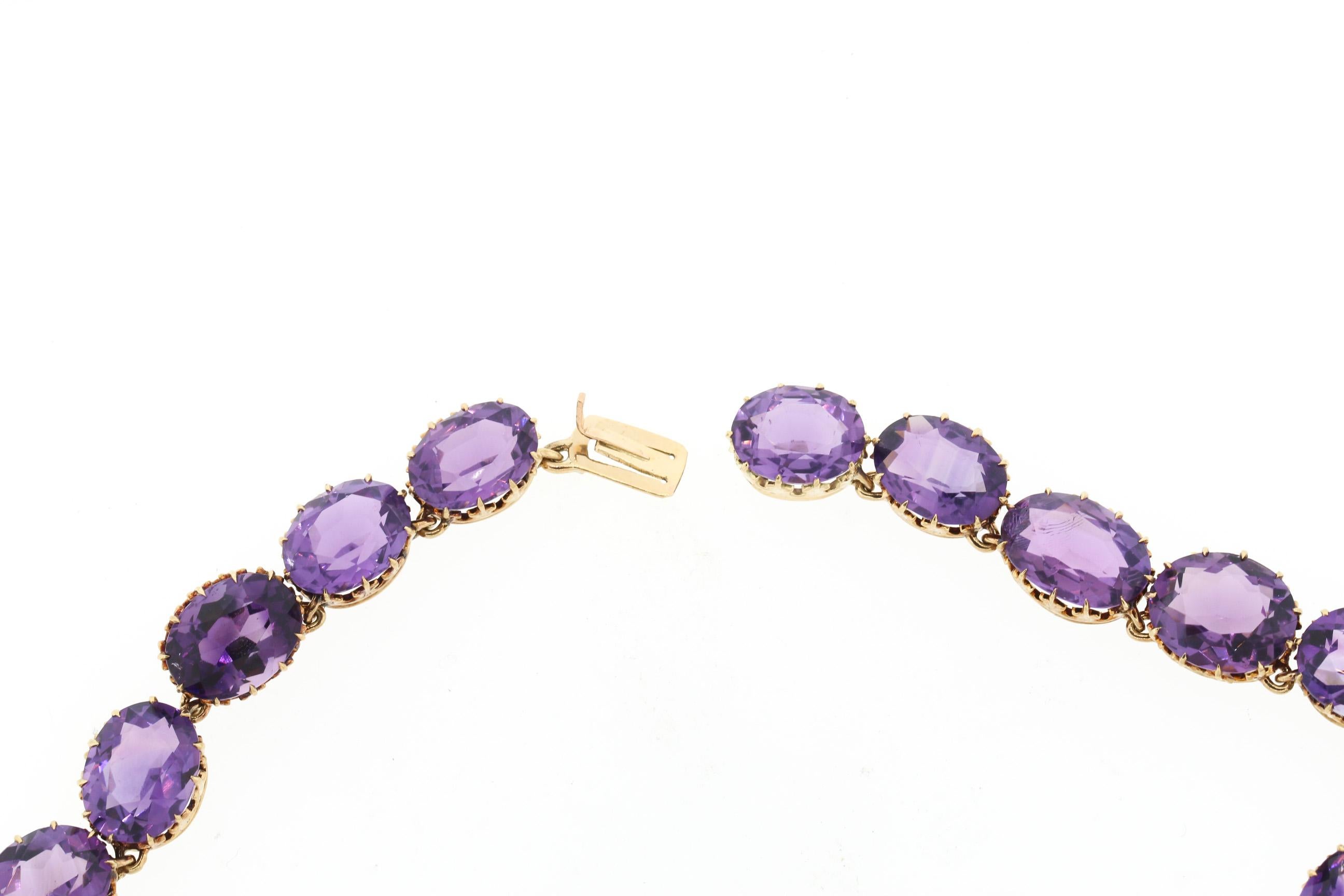 A beautiful antique Victorian 15k yellow gold oval shaped amethyst collet set rivière necklace, circa 1890. This necklace is set with non graduated oval shaped amethyst. The color of the amethyst is a dark rich purple hue, likely Russian in origin.