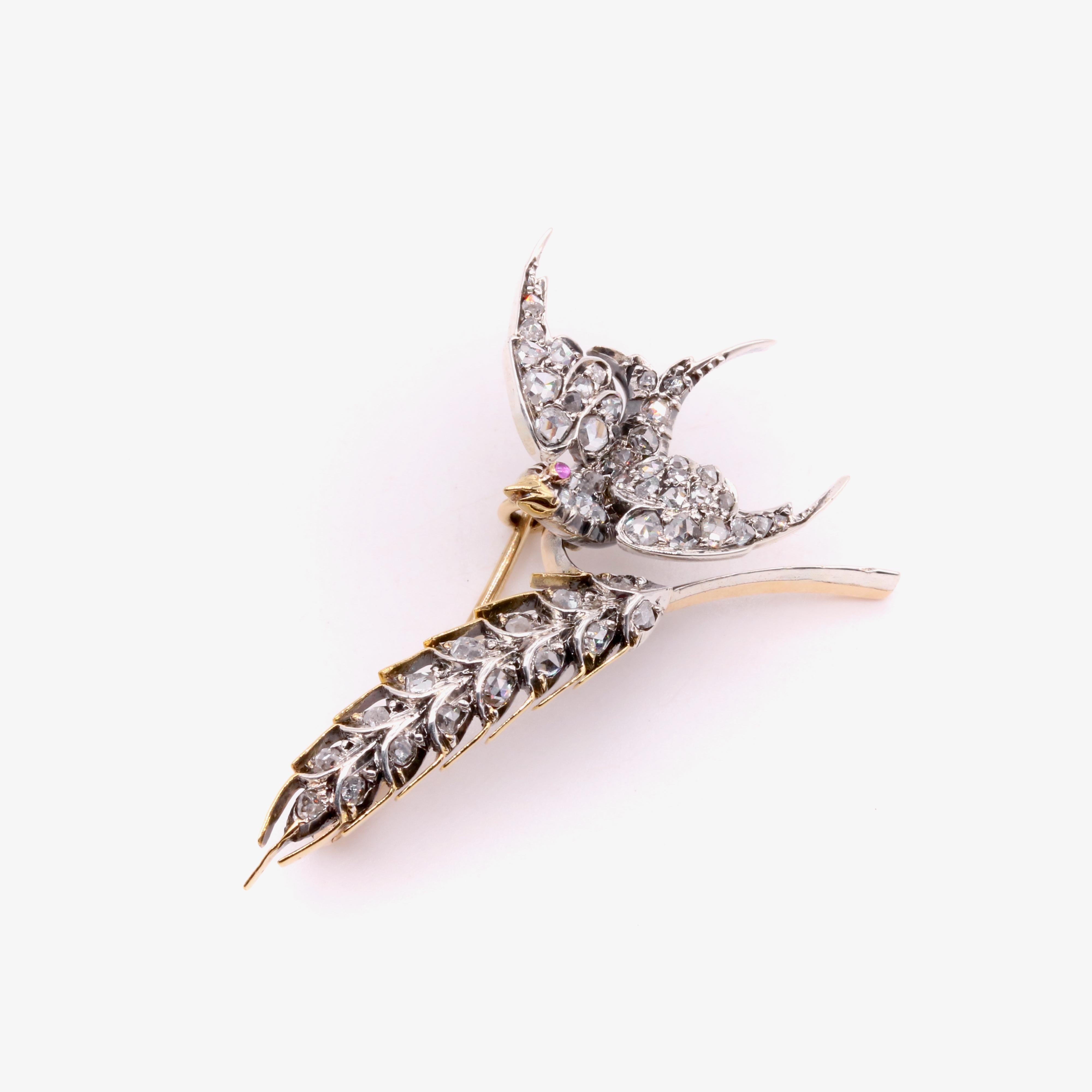 Antica spilla con diamanti, rubini, argento e oro giallo, composta da cinquantaquattro diamanti taglio rosa e un rubino cabochon, in argento e oro giallo a 15 e 9 carati. 

Questa spilla vittoriana è disegnata come una rondine in volo che trasporta