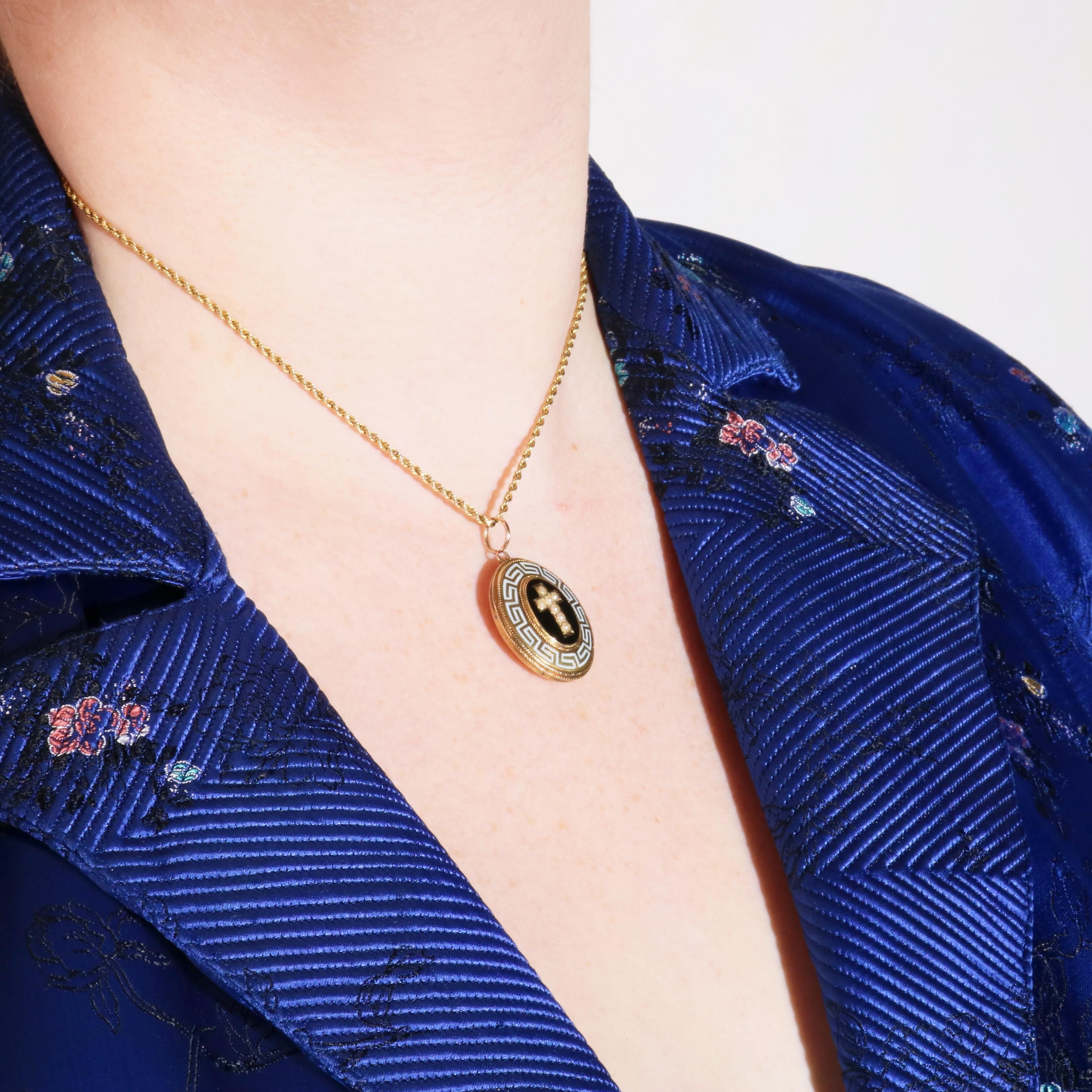 Un médaillon ancien en or jaune, comprenant sept perles de rocaille, de l'émail noir et blanc, et un panneau de verre, à l'intérieur d'un médaillon en or jaune 15 carats. 

Le médaillon est de forme ovale, avec un ovale central en émail noir. A