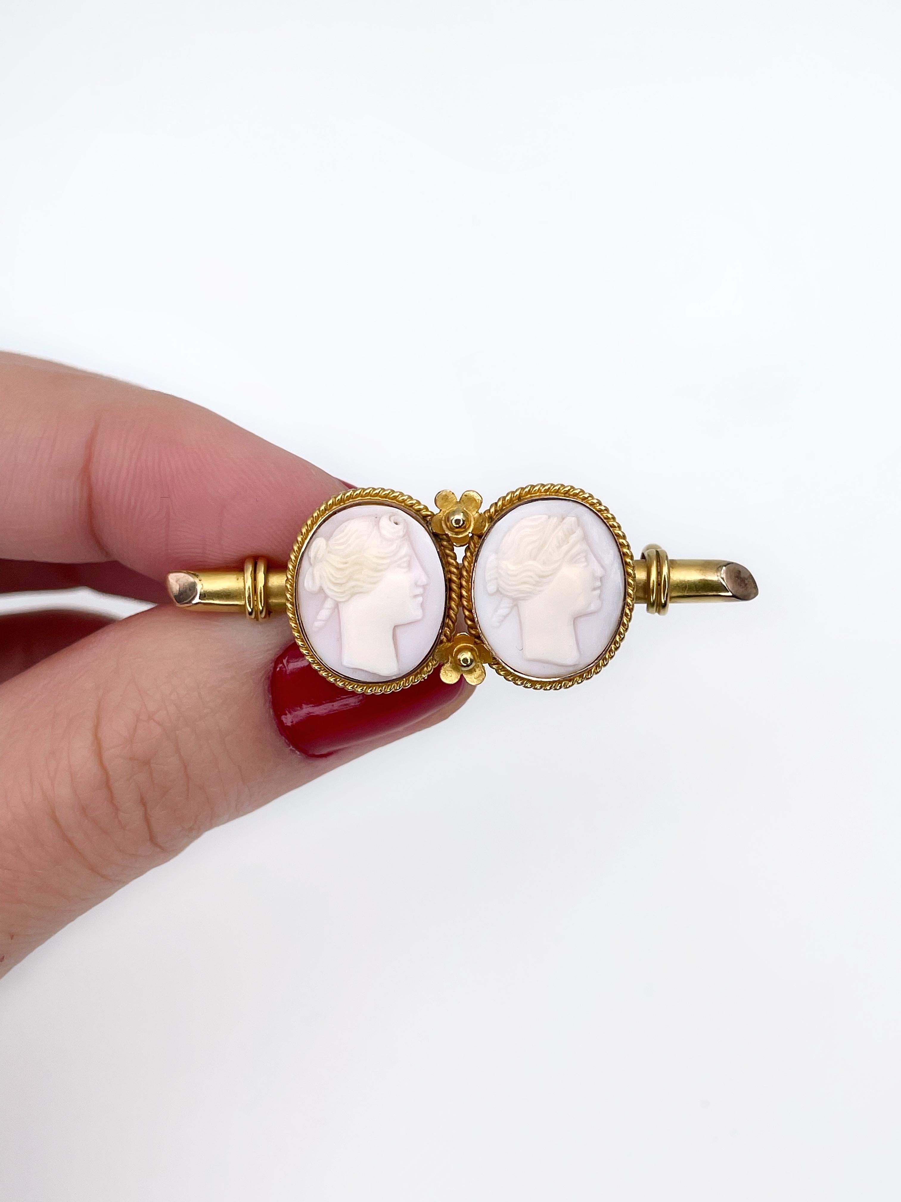 This is an elegant antique brooch crafted in 9K gold. Pin - MET. 

The piece features two cameos depicting right facing persons - possibly man and woman. Cameos are carved from shell. The brooch has floral details.

Length: 4.5cm
Width: 1.6cm
Cameo