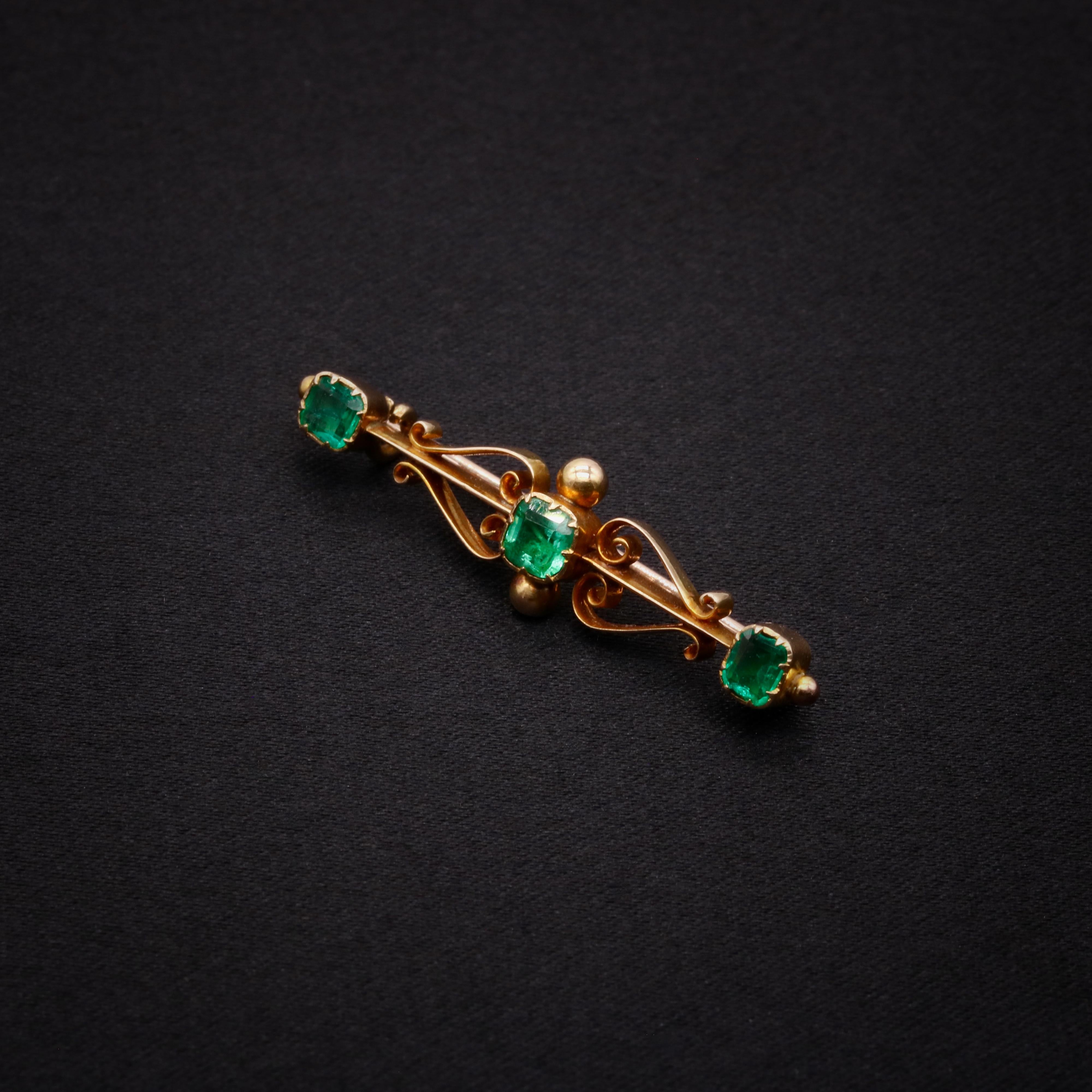 A Victorian emerald, and yellow gold brooch, comprising three square cut emeralds, set in 15 karat yellow gold, with 15 karat yellow gold pin. 

This beautiful Victorian brooch is set with 3 square cut emeralds. The emeralds are held within closed
