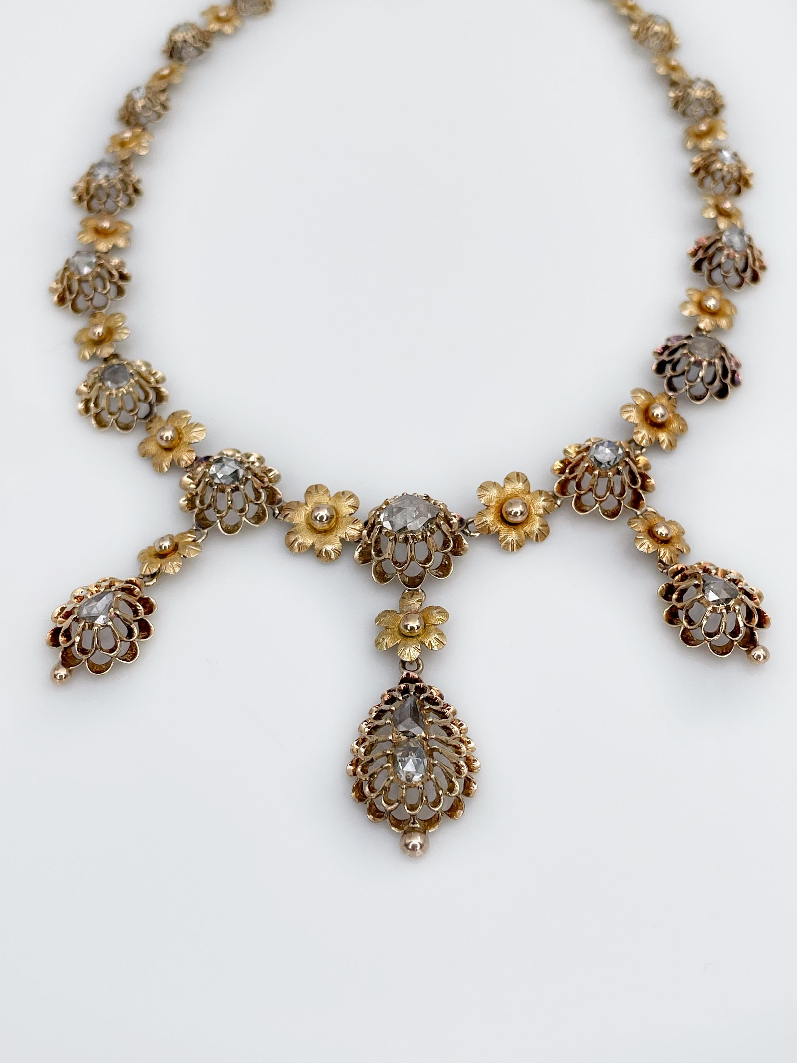 This is an exceptional antique floral design collier in 15K yellow gold. It is composed of 23 rose cut diamonds. Many intricate details make it exceptional and worth of your attention. It has an antique bar and ring clasp and an extra safety chain. 