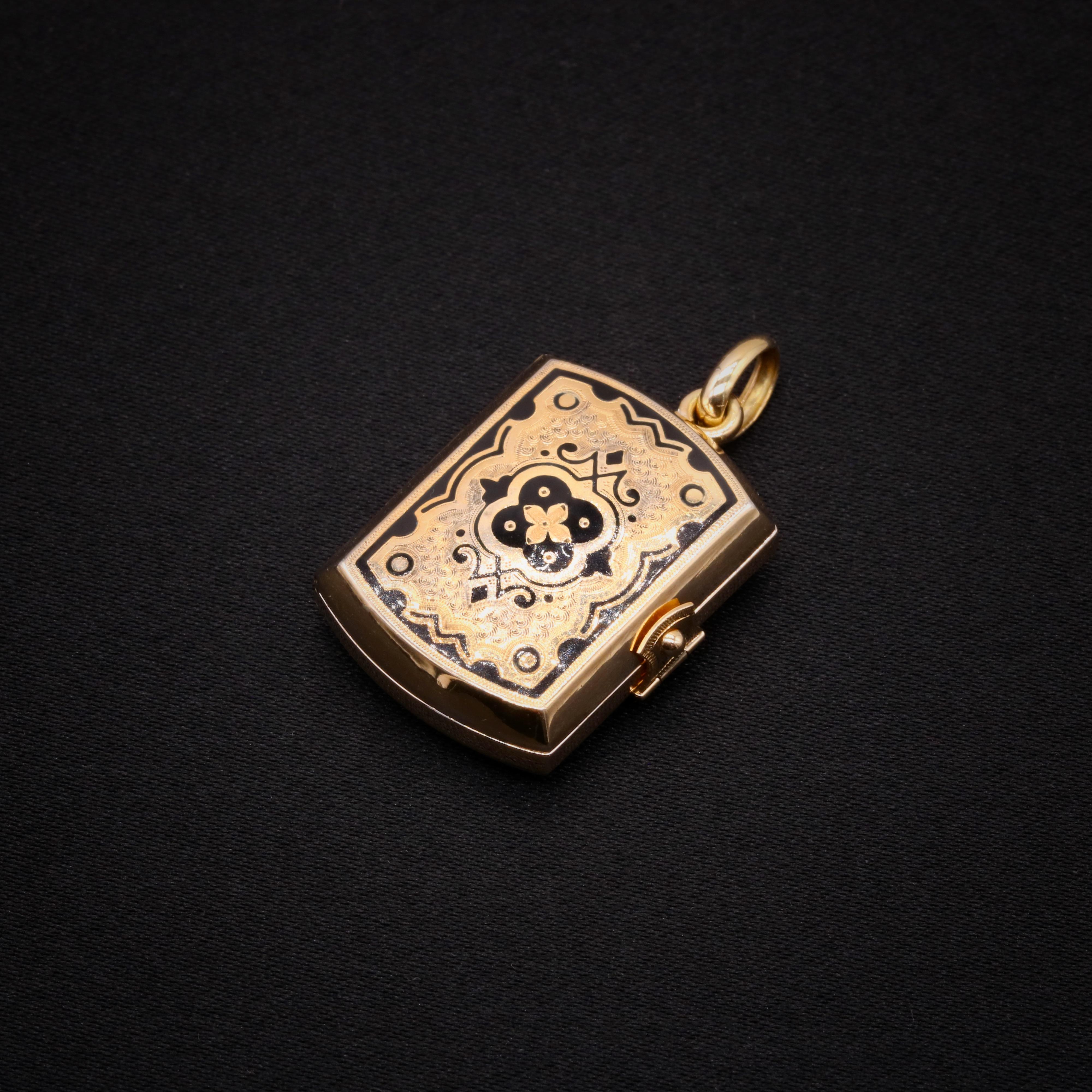 A Victorian yellow gold locket, comprising four glass-covered locket compartments, held within a 15 karat yellow gold ‘book’, adorned with black enamel, with a 15 karat yellow gold bale.

This beautiful locket is formed in the shape of a book. The