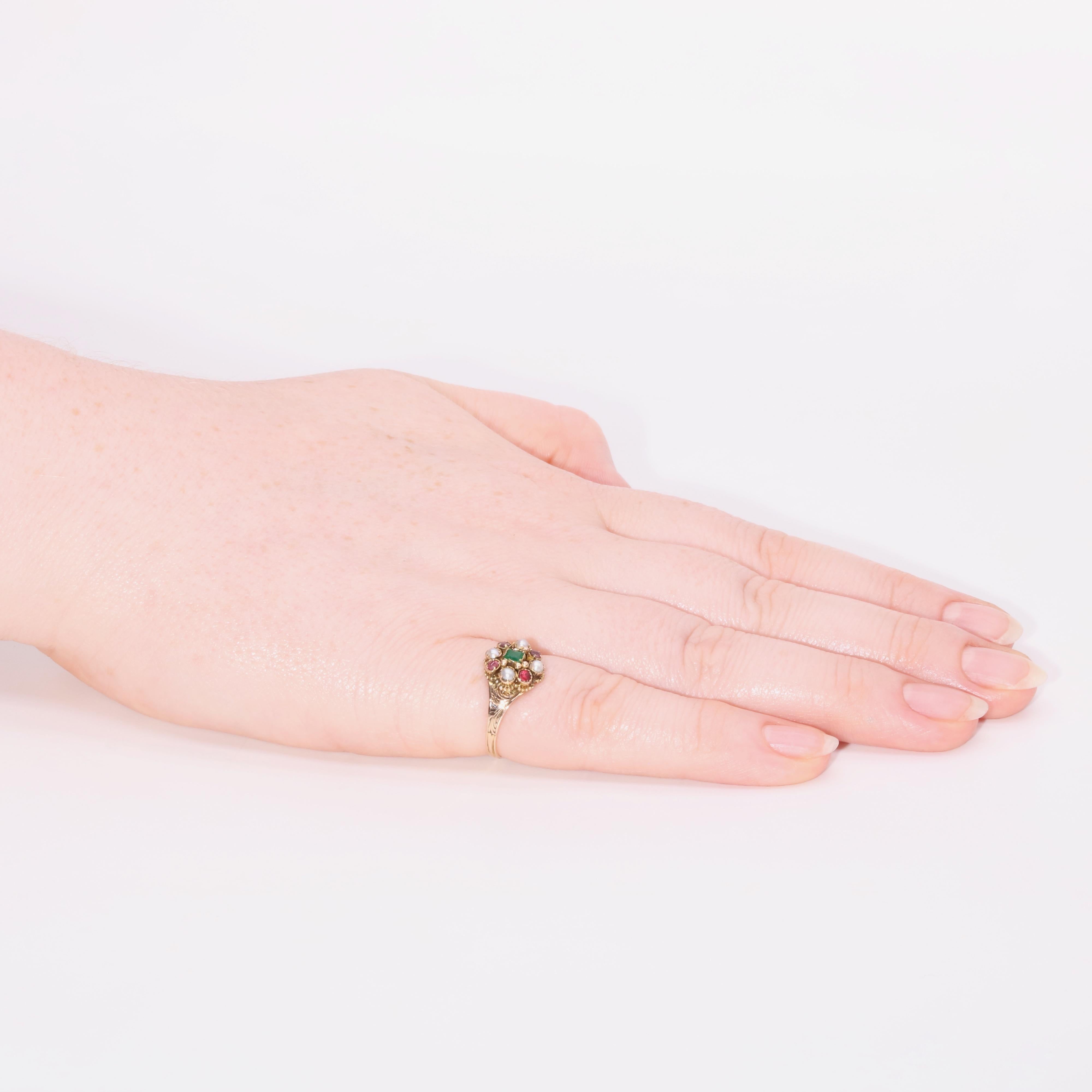 An antique emerald, garnet, pearl, and yellow gold ring, comprising one square shaped emerald, four round cut garnets, and four half pearls, set in 15 karat yellow gold, to a band of 15 karat yellow gold. 

This lovely ring is set to the centre with