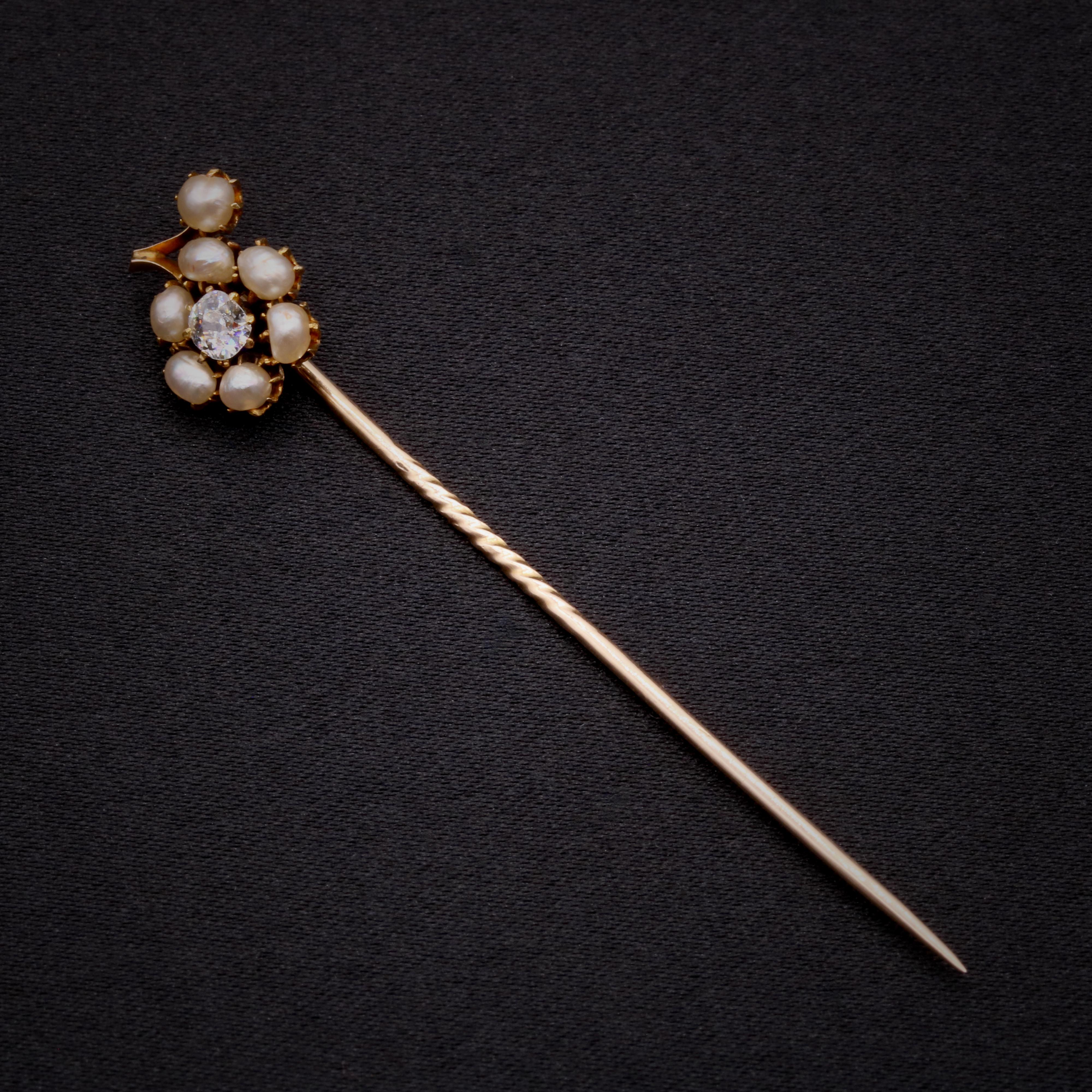 An antique diamond, pearl, and yellow gold stick pin, comprising an old mine cut diamond, and seven seed pearls, in 15 karat and 9 karat yellow gold. 

This lovely stick pin is set to the centre with a sparkling old mine cut diamond. The diamond is