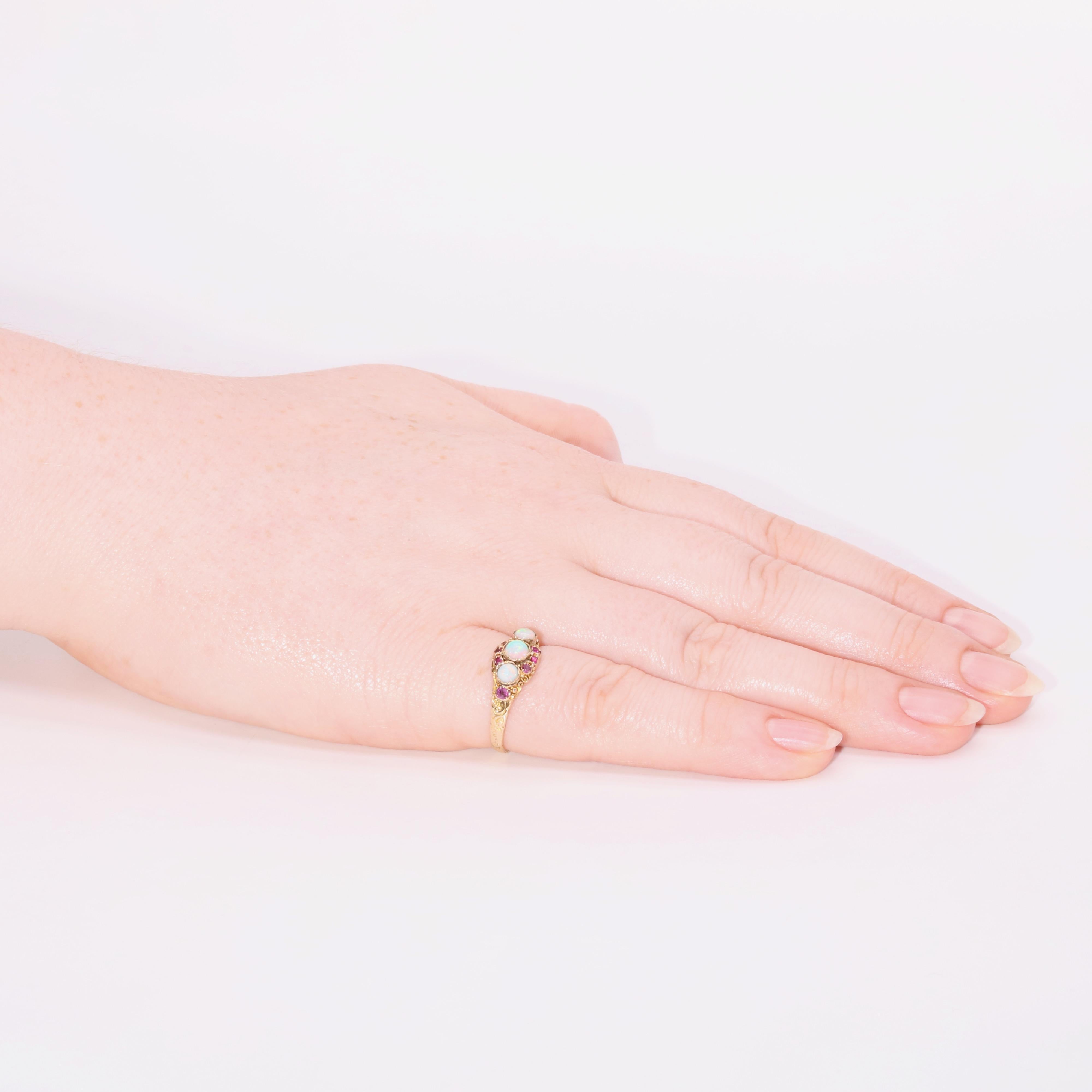 An antique opal, ruby, and yellow gold ring, set with three round cabochon opals, and eight cushion shaped rubies, set in 15 karat yellow gold, to a 15 karat yellow gold band. 

This lovely Victorian ring is set to the centre with a beautiful, round