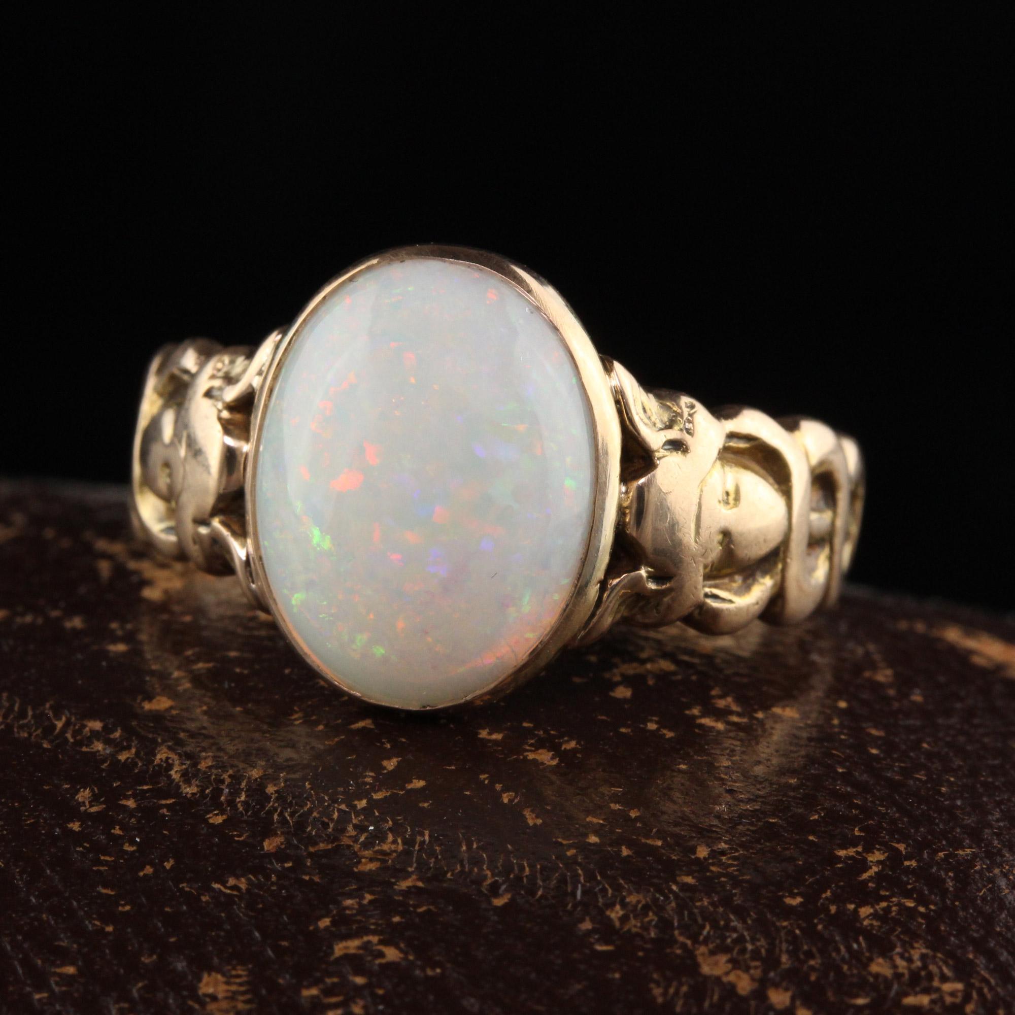 Beautiful Antique Victorian 15K Yellow Gold Opal Asclepios Carved Ring. This gorgeous opal Victorian ring is crafted in 15K yellow gold. The center is a beautiful white opal cabochon with beautiful play of color that is set in a Victorian mounting