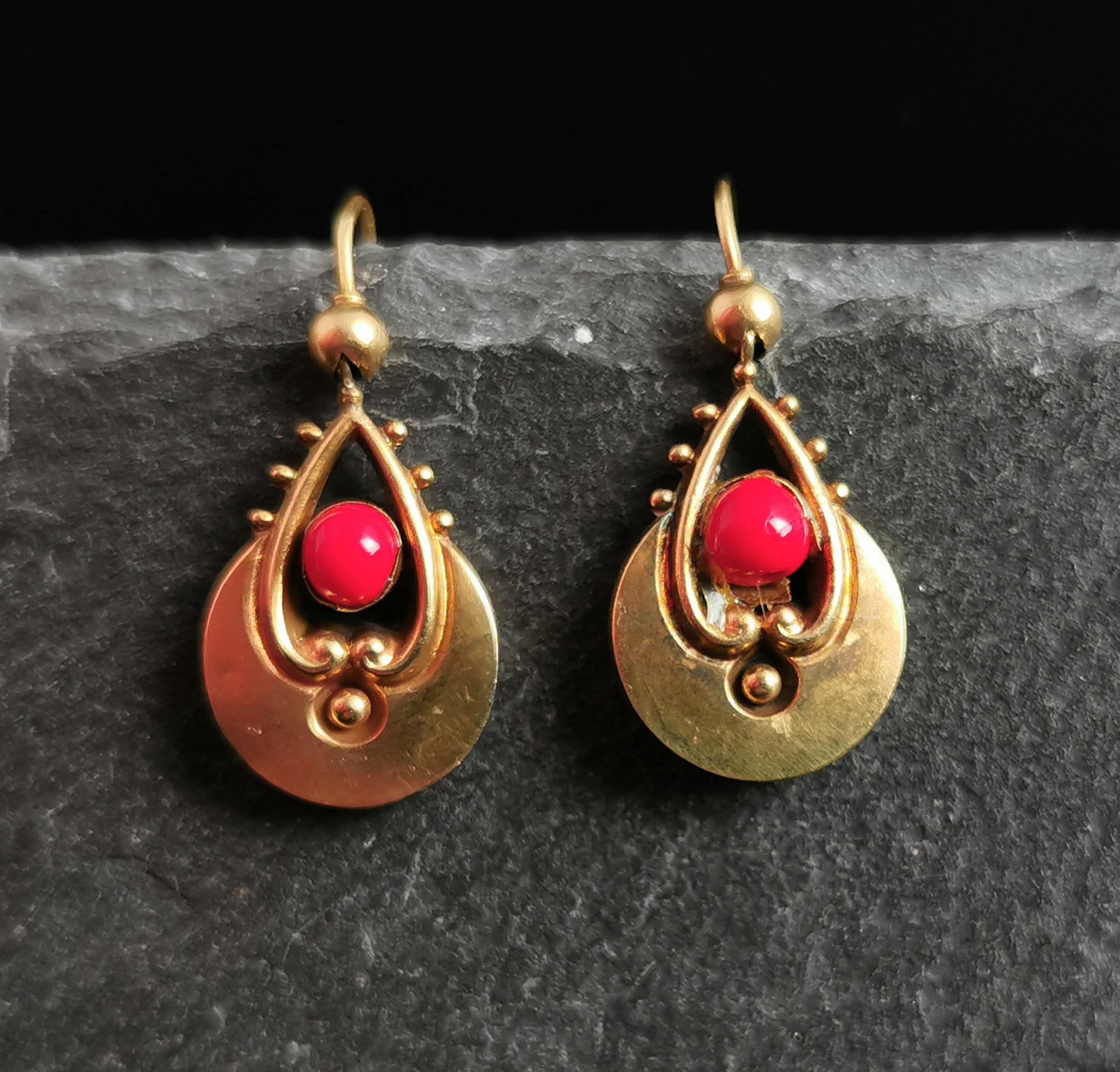 A beautiful pair of Antique 15ct yellow gold dangly earrings.

Etruscan revival style gold drops with scroll work and beaded detailing.

They have been set with a coral coloured paste bead on each side, these are not original but were added a long