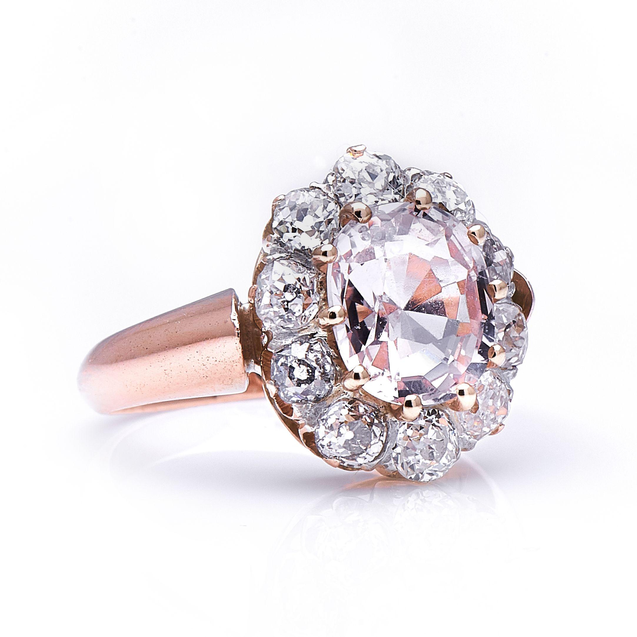 Pale peach sapphire and diamond ring. At the centre of this ring is a charming sapphire of a very subtle pale peach colour, weighing approximately 2.30 carats. Its delicate hue, coupled with its excellent transparency and well-proportioned cut make