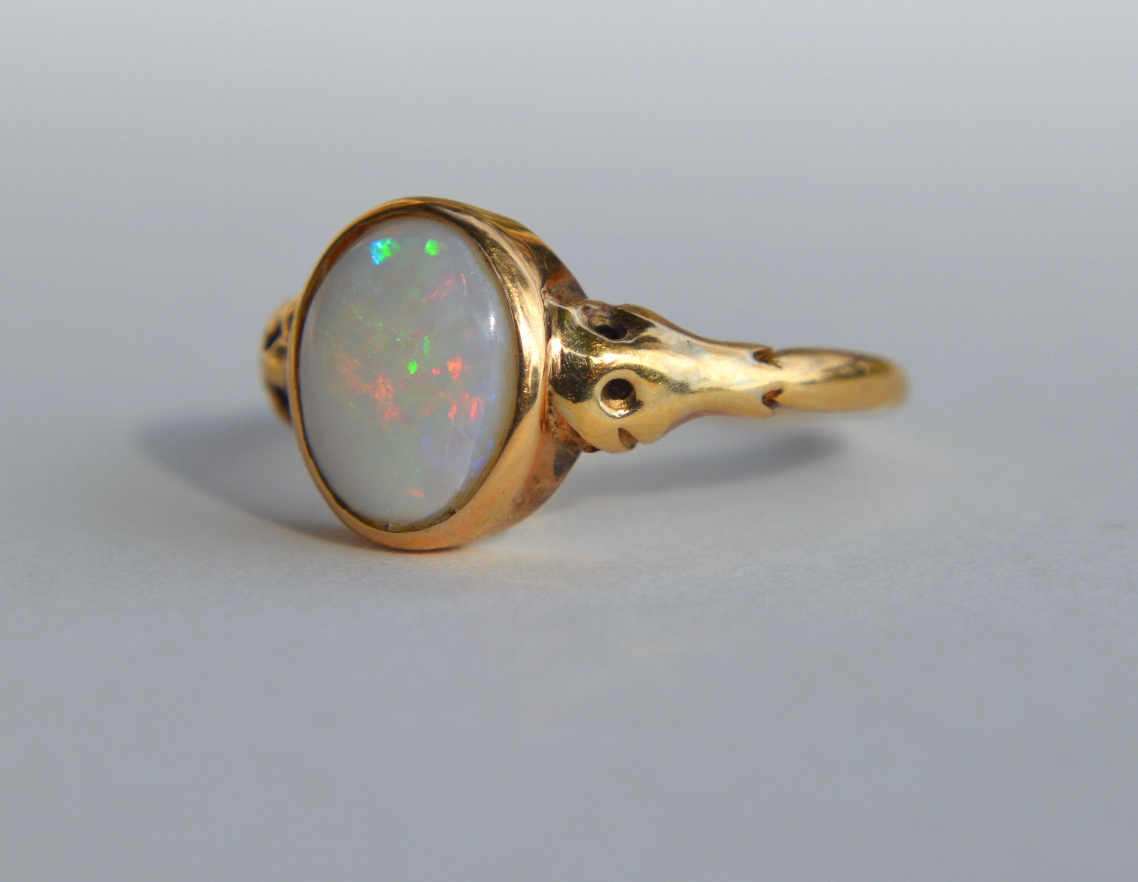 Lovely antique Victorian era English origin circa late 1800s 18K yellow gold 1.86 carat opal cabochon ring. Size 6.5, can be resized by a jeweler. In very good condition. Snake head design on shoulders.  The opal is Australian with rainbow fiery