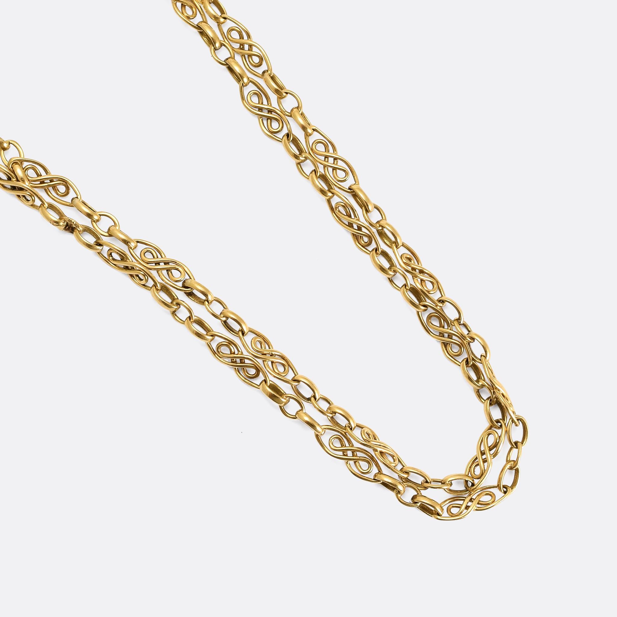 An incredible, finely worked antique guard chain dating from the late Victorian era, circa 1890. It's French, crafted in 18 karat gold, and features beautiful swirling gold links and a ring bolt clasp to add charms or a pendant. Fully hallmarked and