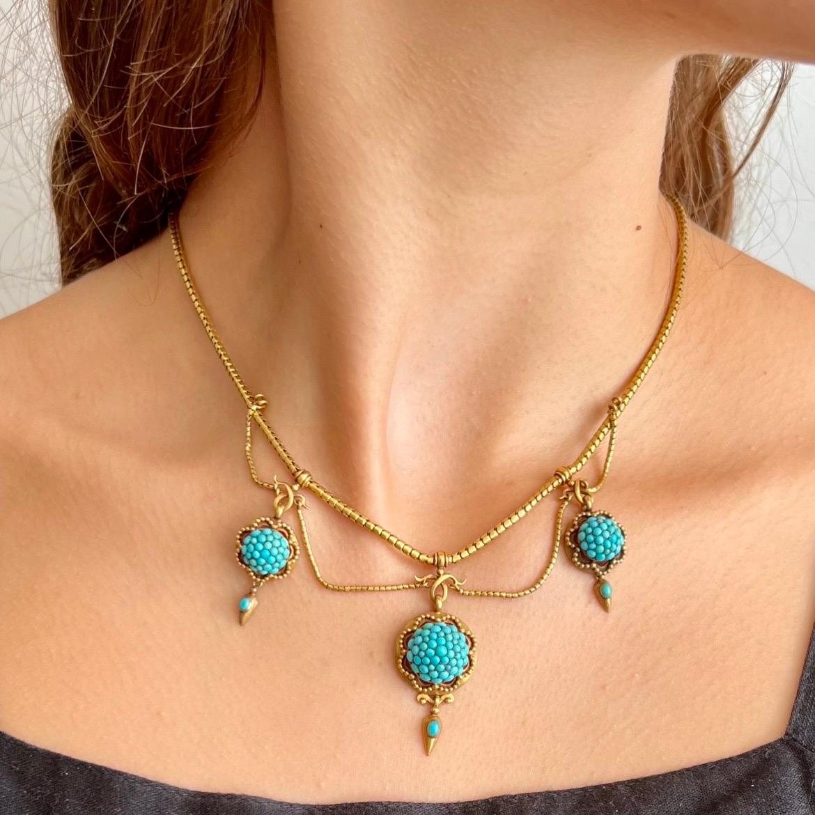 This beautifully fine necklace is made in Victorian times and created in warm 18 karat gold and set with turquoise cabochon stones. The necklace is created with three dome pavé turquoise circular pendants surrounded by gold beading and set with a