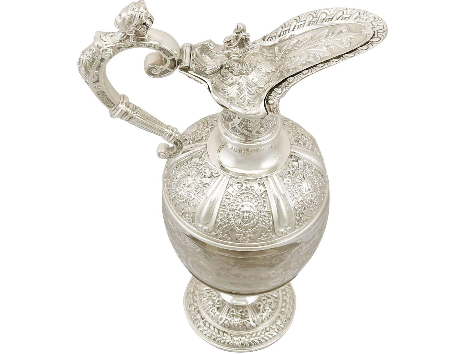 A magnificent, fine and impressive antique Victorian sterling silver and glass claret jug; an addition to our silver jug collection.

This magnificent antique Victorian English sterling silver and glass Cellini style claret jug has a ewer shaped