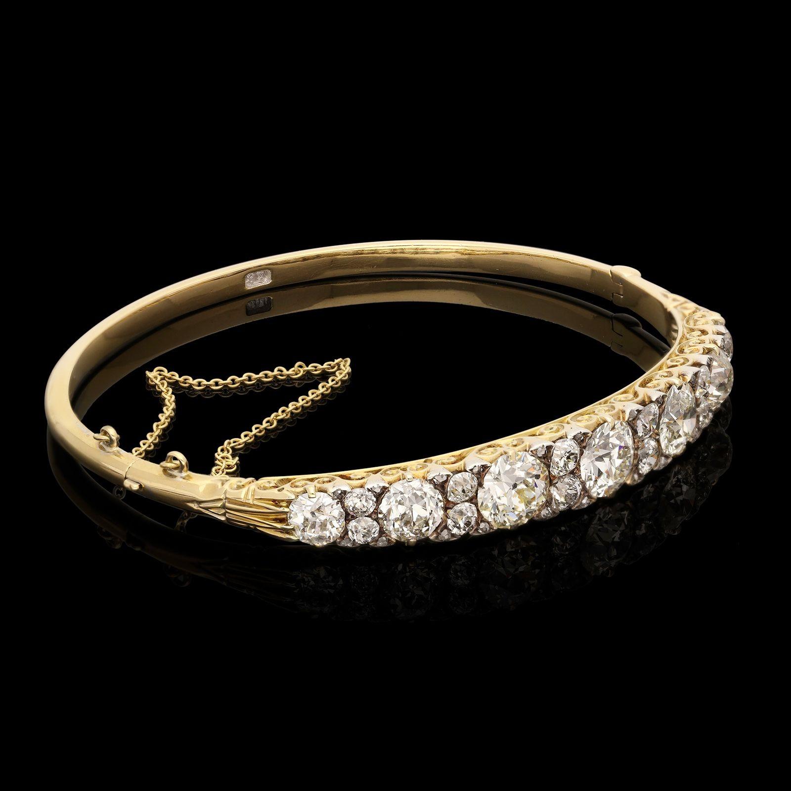 A beautiful Victorian gold and diamond hinged bangle c.1890s, the classic hoop style bangle formed of 18ct yellow gold and set to the front with seven graduated old European brilliant cut diamonds interspersed with pairs of smaller old European