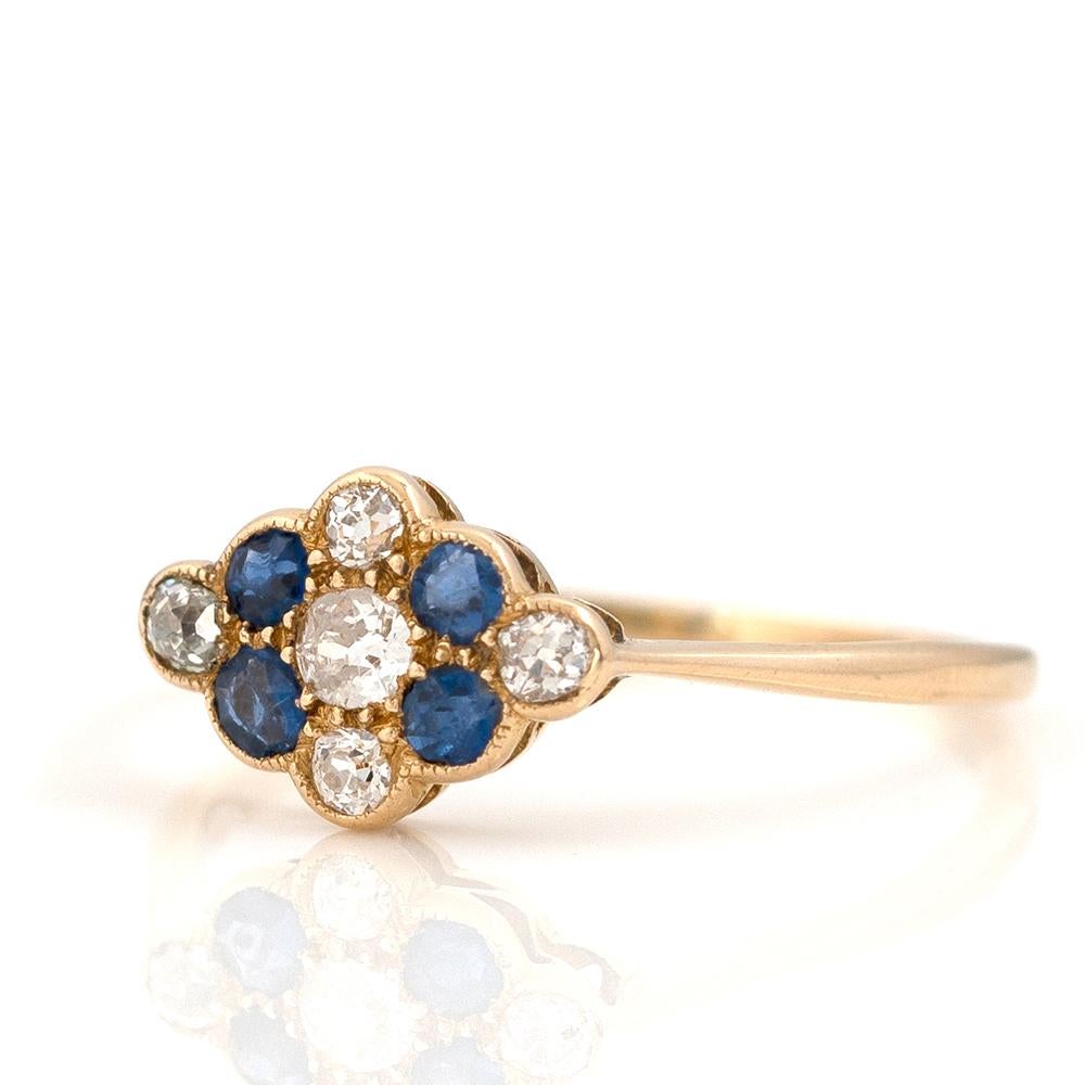 Unser wunderschöner antiker viktorianischer Ring aus 18 Karat Gelbgold ist mit leuchtend blauen Saphiren und weißen Diamanten in einer floralen Millgrain-Fassung geschmückt. Seine fachmännische Verarbeitung und seine Noblesse machen ihn zu einem