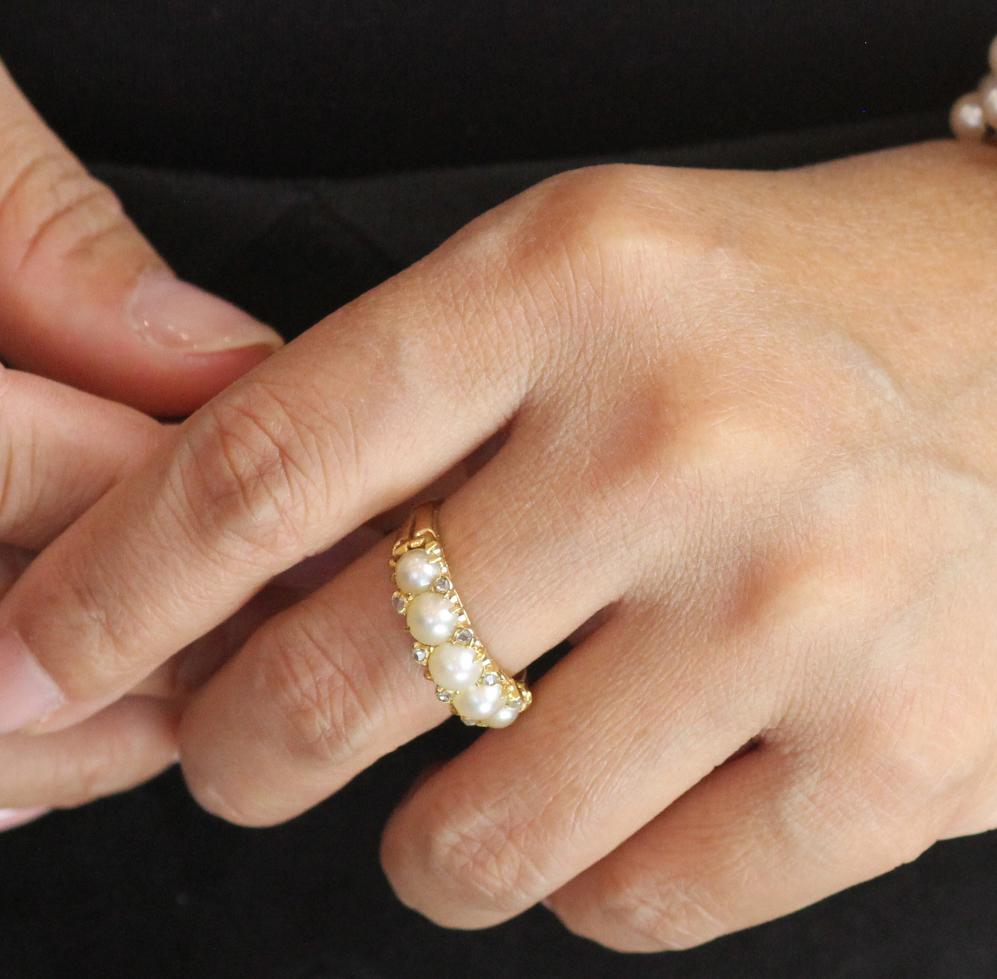 Un bellissimo e ricco anello in oro giallo 18 ct con cinque perle coltivate leggermente graduate e affiancate da piccoli e scintillanti cristalli di diamante taglio vecchio, volutamente non abbinati, ognuno con un taglio leggermente diverso.  Con