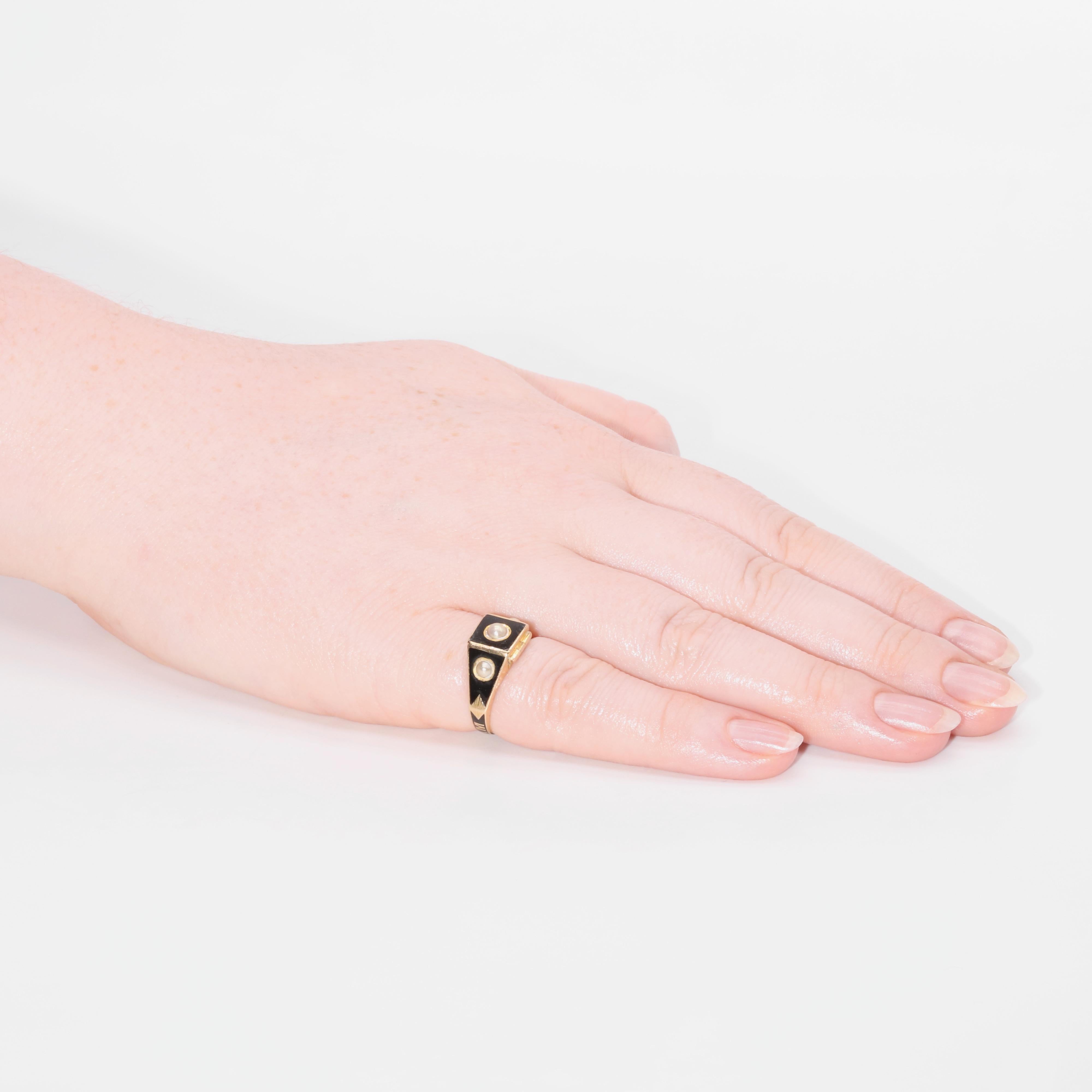 An antique gold, black enamel and pearl ring, comprising three seed pearls and black enamel, with a hinged locket compartment containing plaited hairwork, set in 18 karat yellow gold, to an 18 karat yellow gold band. 

This beautiful piece of