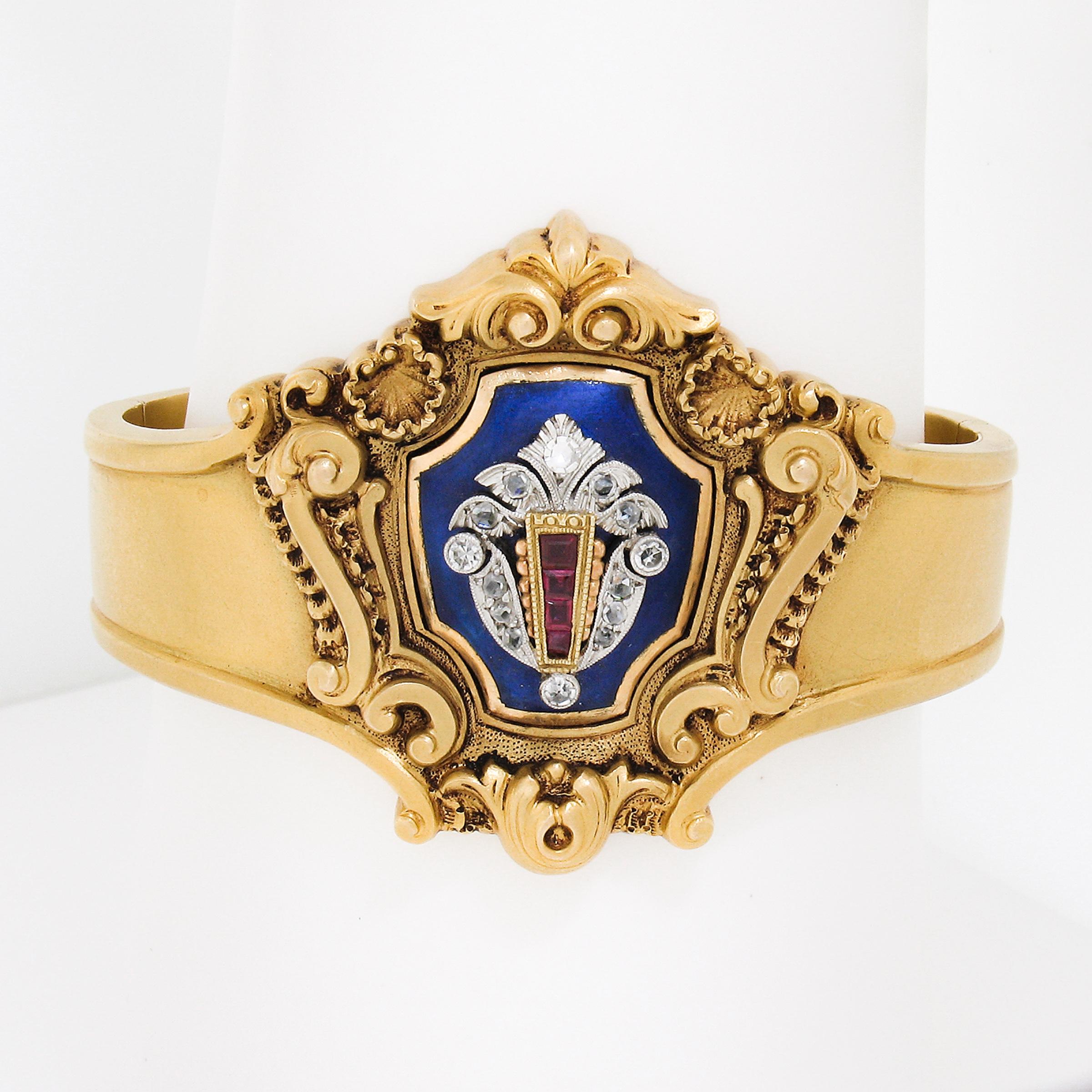 This jaw dropping antique bangle bracelet is crafted in solid 18k yellow gold in the early Victorian period. The incredible design features a dramatic center piece that is decorated with floral and scroll repousse work, and is adorned with royal