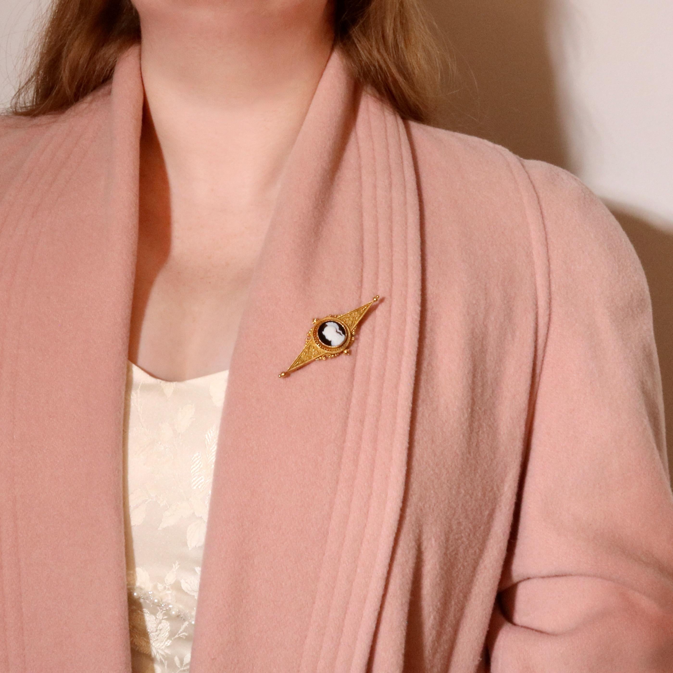 Spilla vittoriana in agata a bande e oro giallo, composta da un pannello di agata a bande intagliate, incastonato in oro giallo 18 carati, con perno e accessori in oro giallo 18 carati.  

Questa sorprendente spilla vittoriana è incastonata al