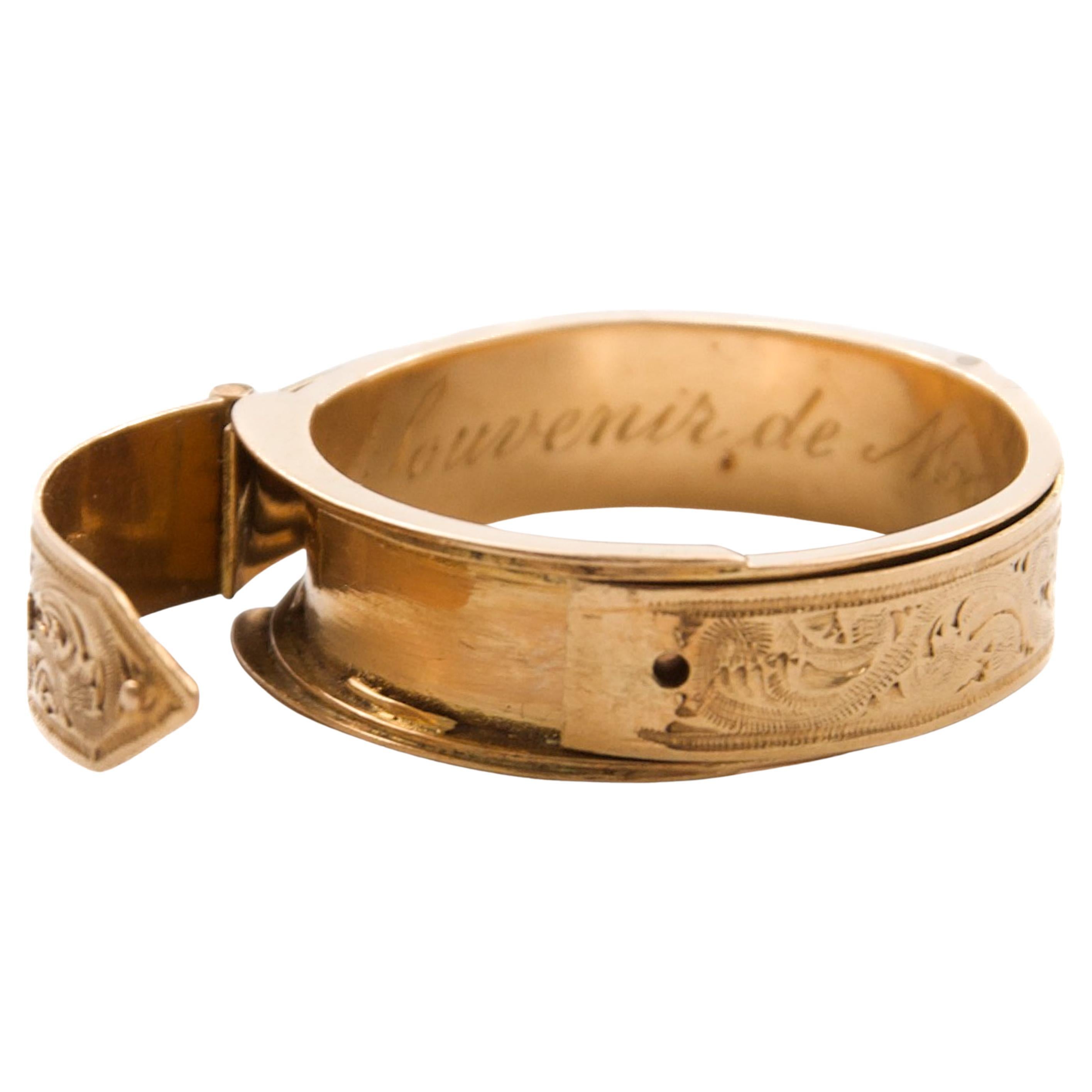 Cette magnifique bague à boucle ancienne a été réalisée en or jaune 18 carats et date de la fin du XIXe siècle, à l'époque victorienne. La bague présente un motif floral finement gravé qui décore l'ensemble de l'anneau, illustrant l'art et le