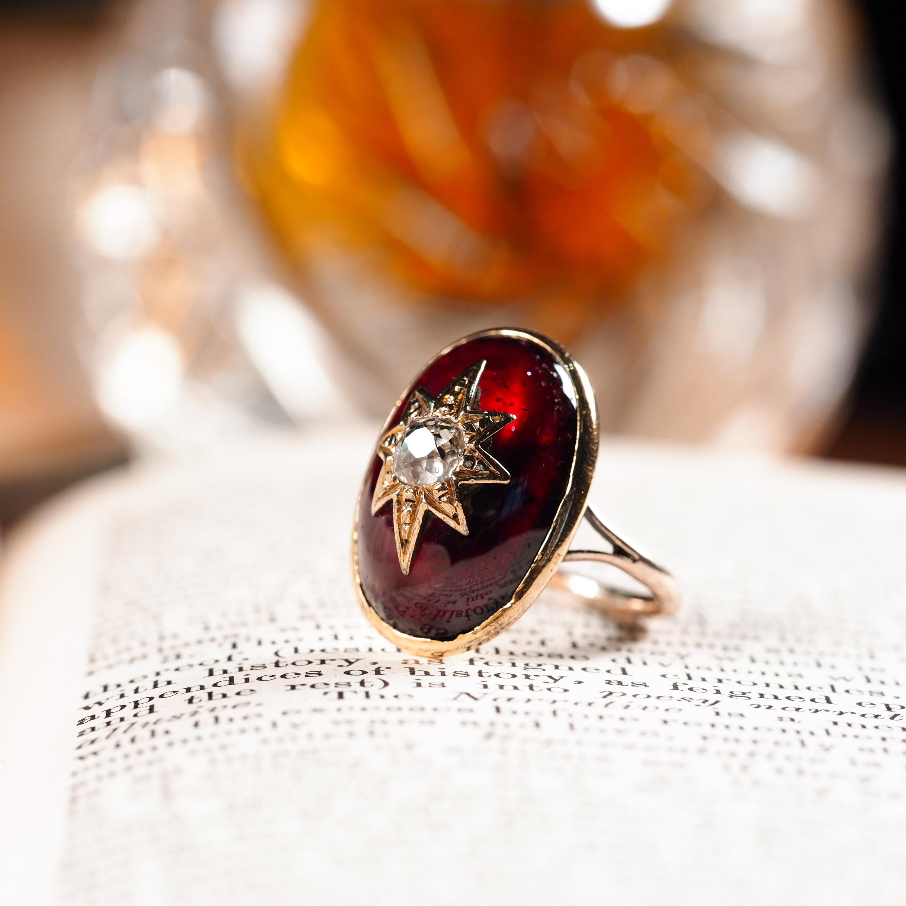 We are delighted to offer this large and majestic 18ct gold garnet ring made in the early Victorian period c.1840.
 
Distinctly antique and exquisitely designed, this ring features a large garnet cabochon set in 18ct gold with a central diamond set